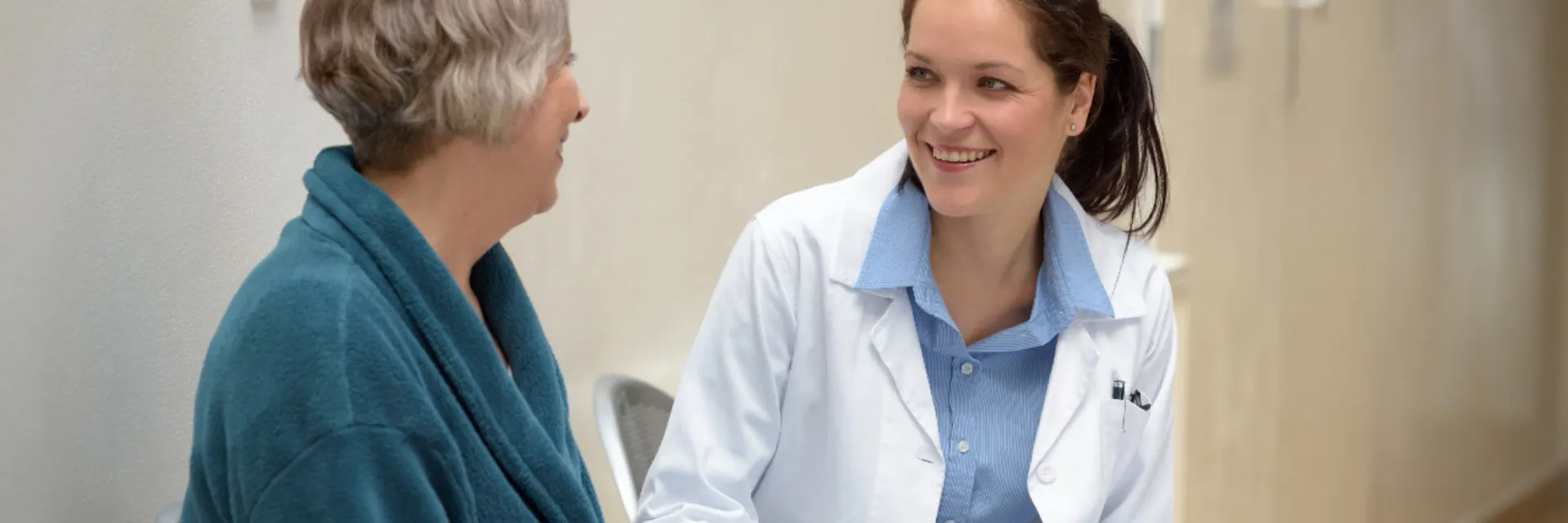 Une femme médecin souriante parle à une patiente âgée à l'hôpital