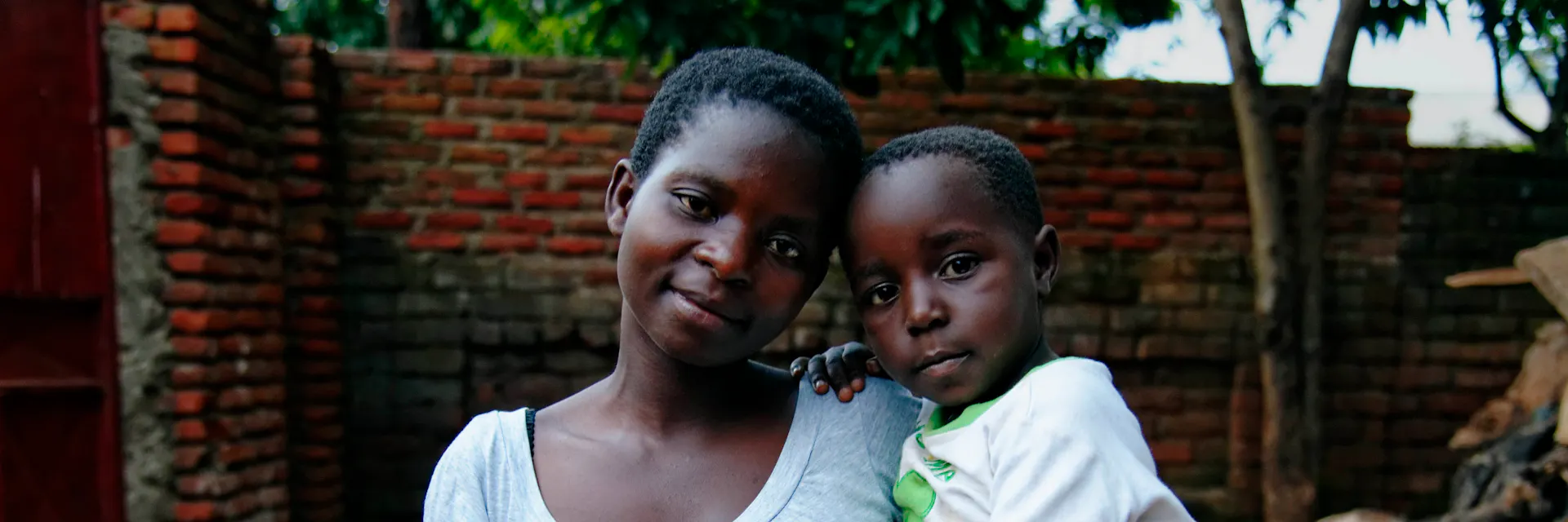 Portrait de Pamela Maposah, 18 ans, avec l'un des deux enfants de la famille pour laquelle elle travaille comme travailleur domestique au Malawi. (2013)