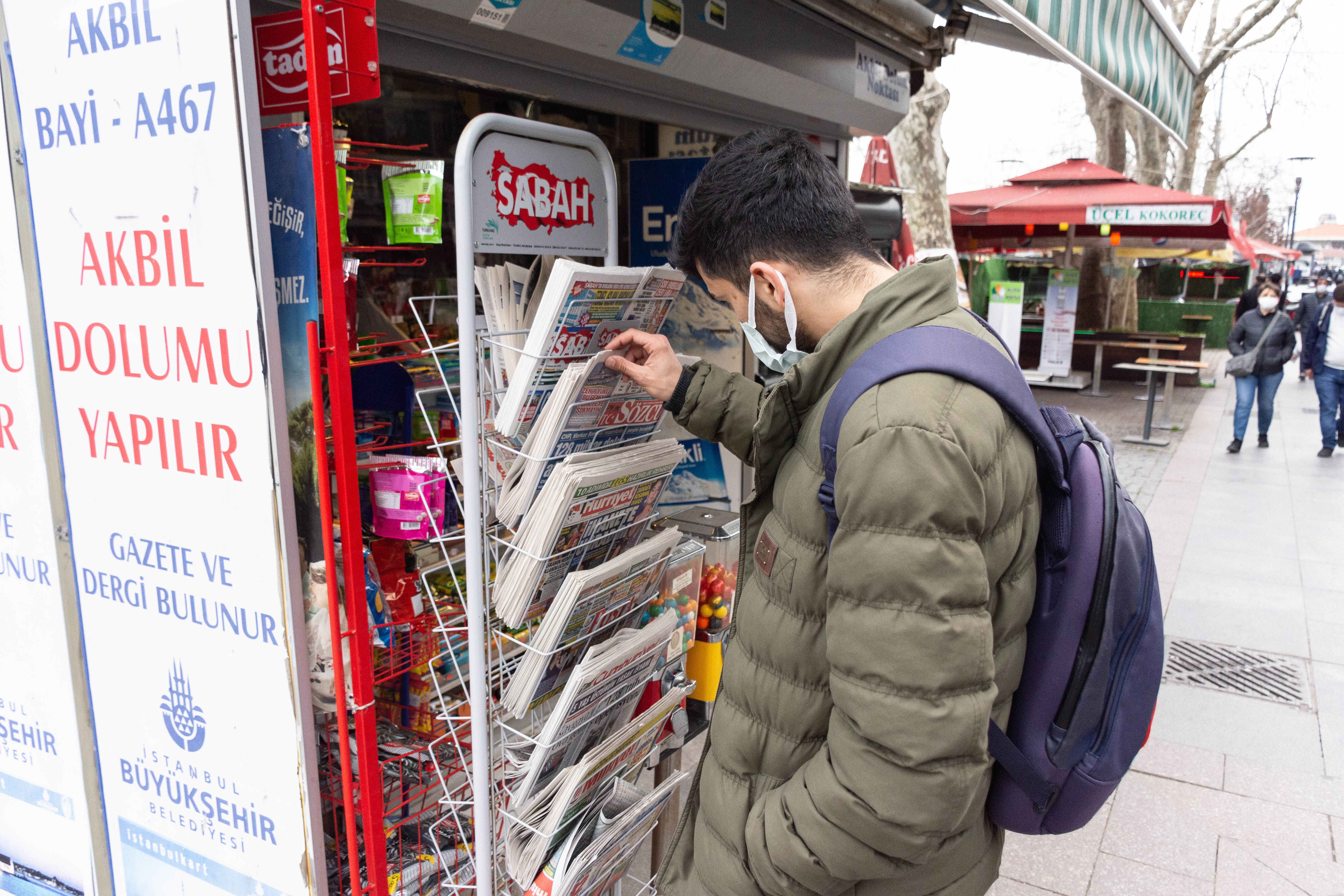 Morshed selects a Turkish newspaper from a newspaper stand. 