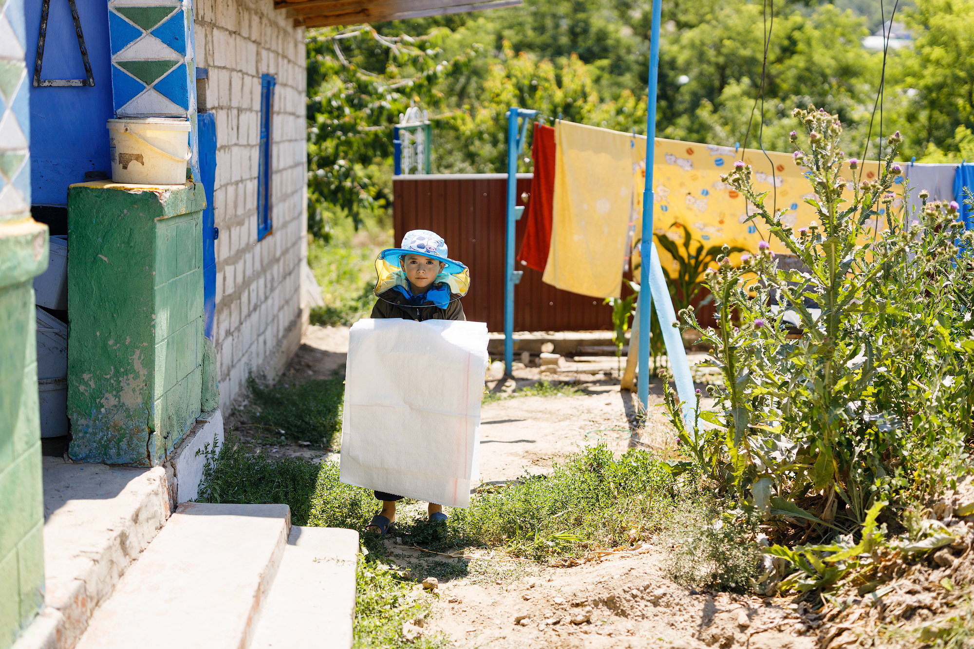 Gabriel, hijo de Viorica, fuera de su casa con un sombrero de apicultor. 