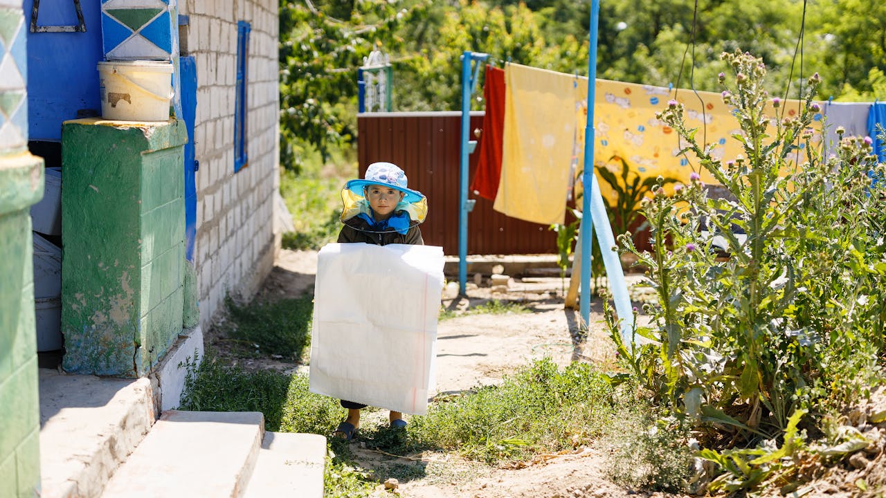 Viorica’s son Gabriel stands outside his home with a beekeeper’s hat on.