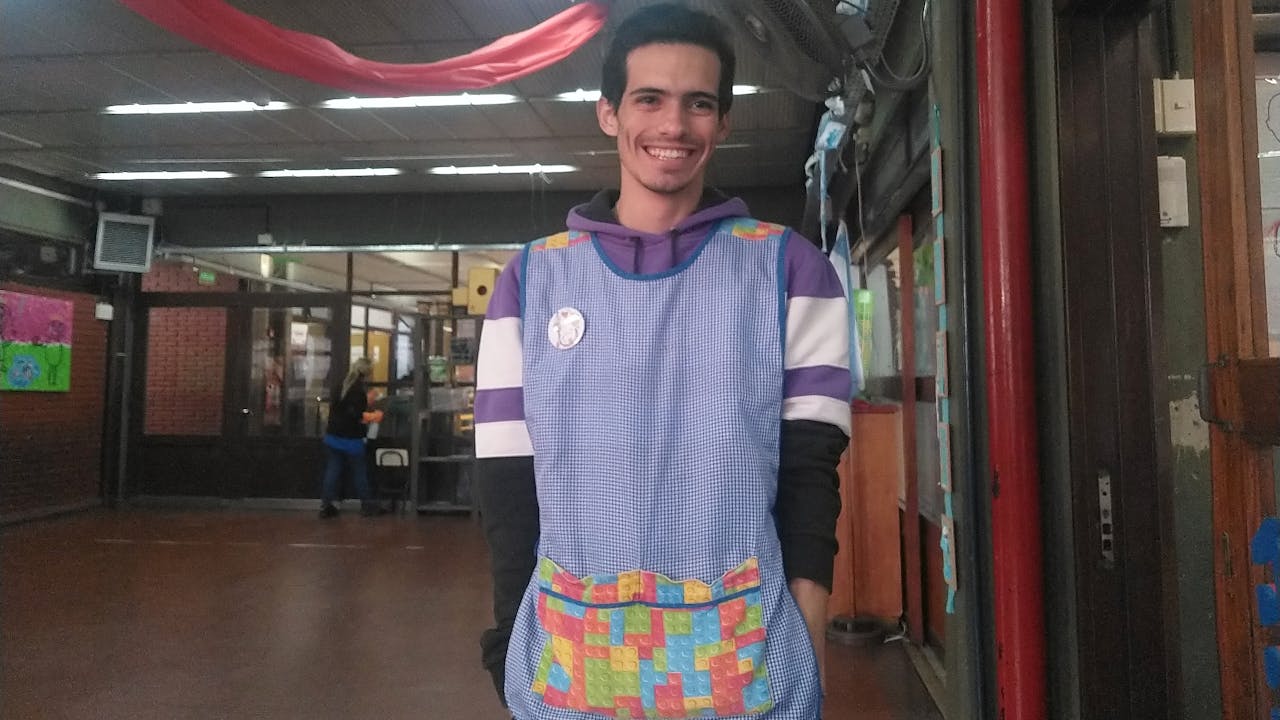 Federico porte une blouse à carreaux bleus et blancs qu’il portait lorsqu’il était enseignant stagiaire. 