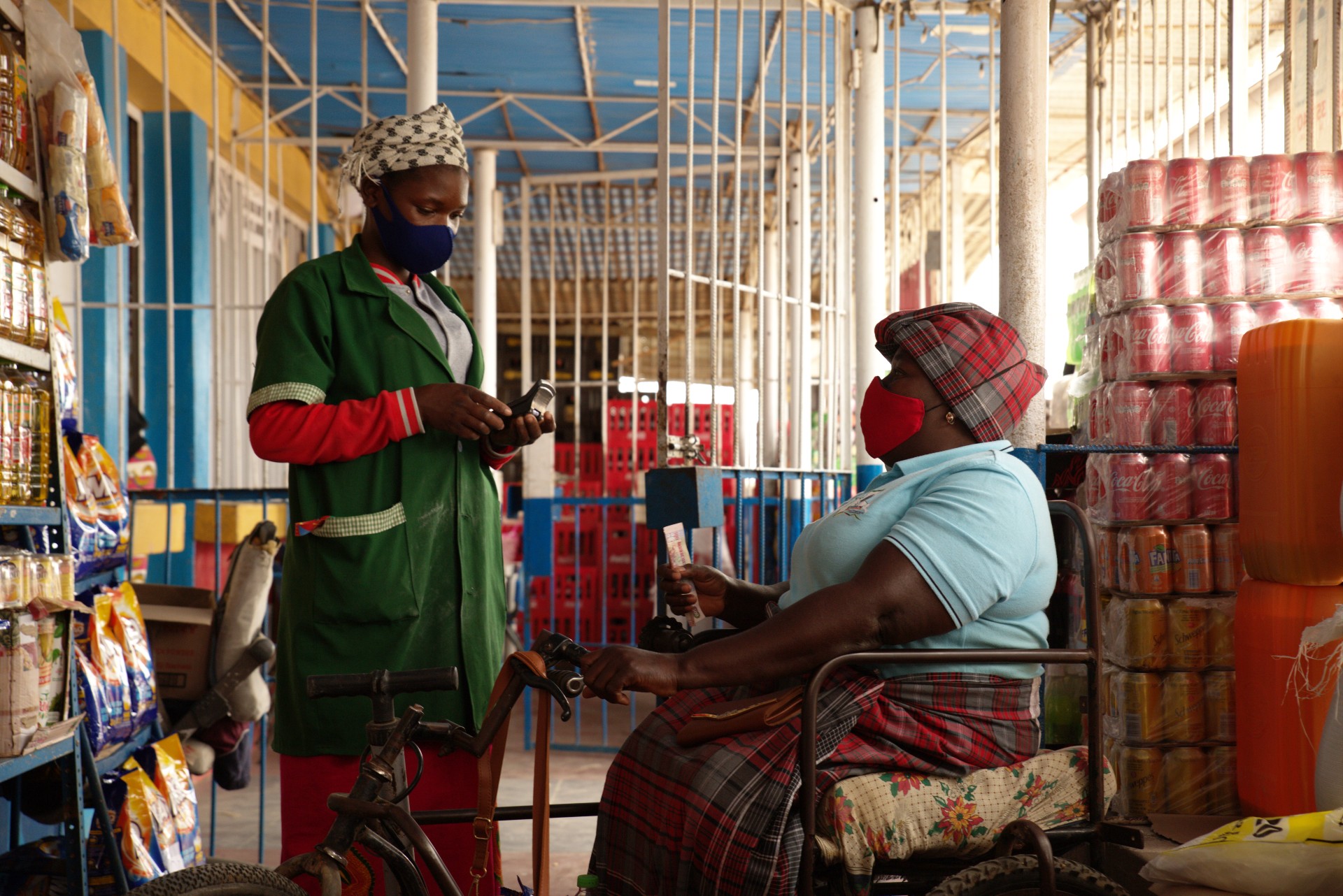 Linda Sarmento in a food store with a sales clerk.  Food is stacked on shelves.