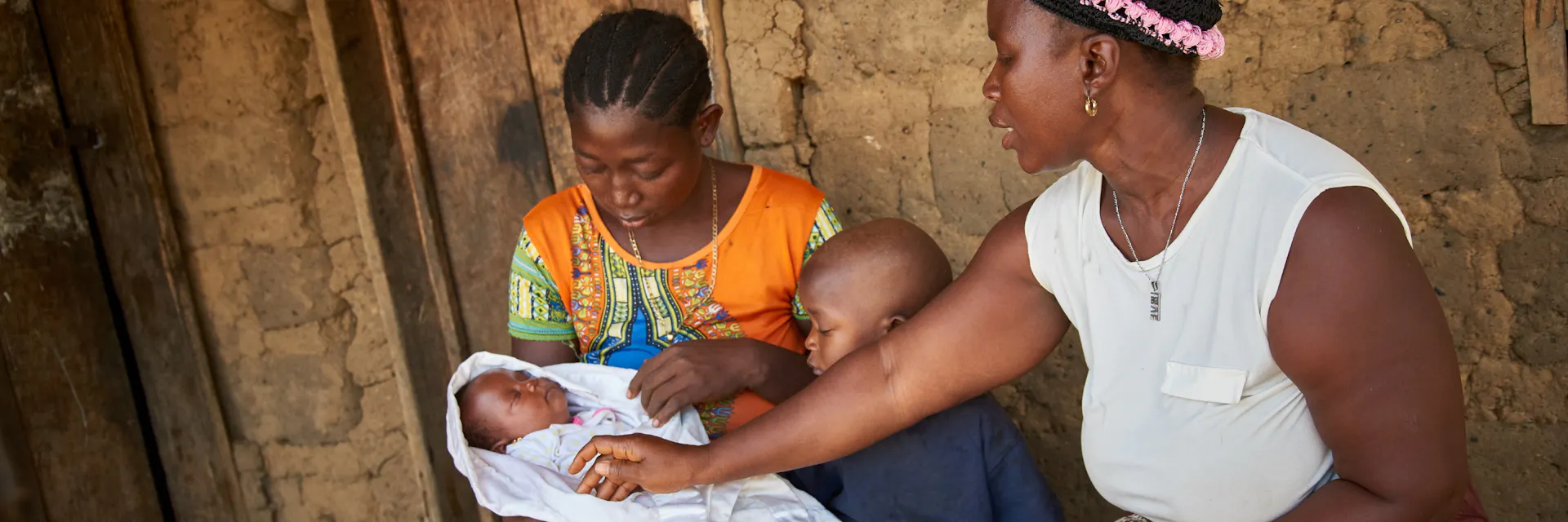 Community health worker Memuna Conteh consults Hawa Kargbo, late twenties on maternal health as she holds Fatmata, her 6 weeks old child in Karineh village, Magbema chiefdom, Kambia district, Sierra Leone on April 3, 2017.