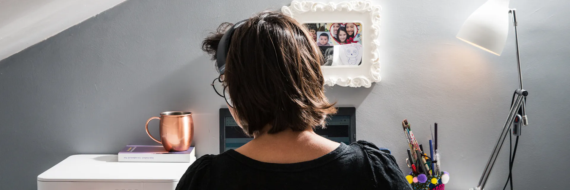 Woman teleworks at desk.