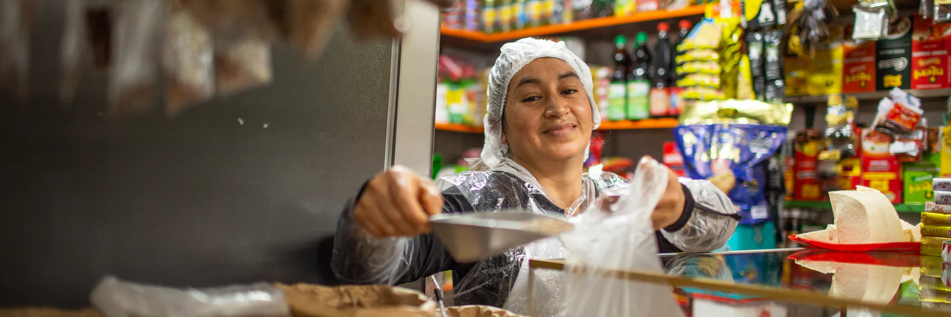 La vendedora detrás del mostrador pesa la mercancía