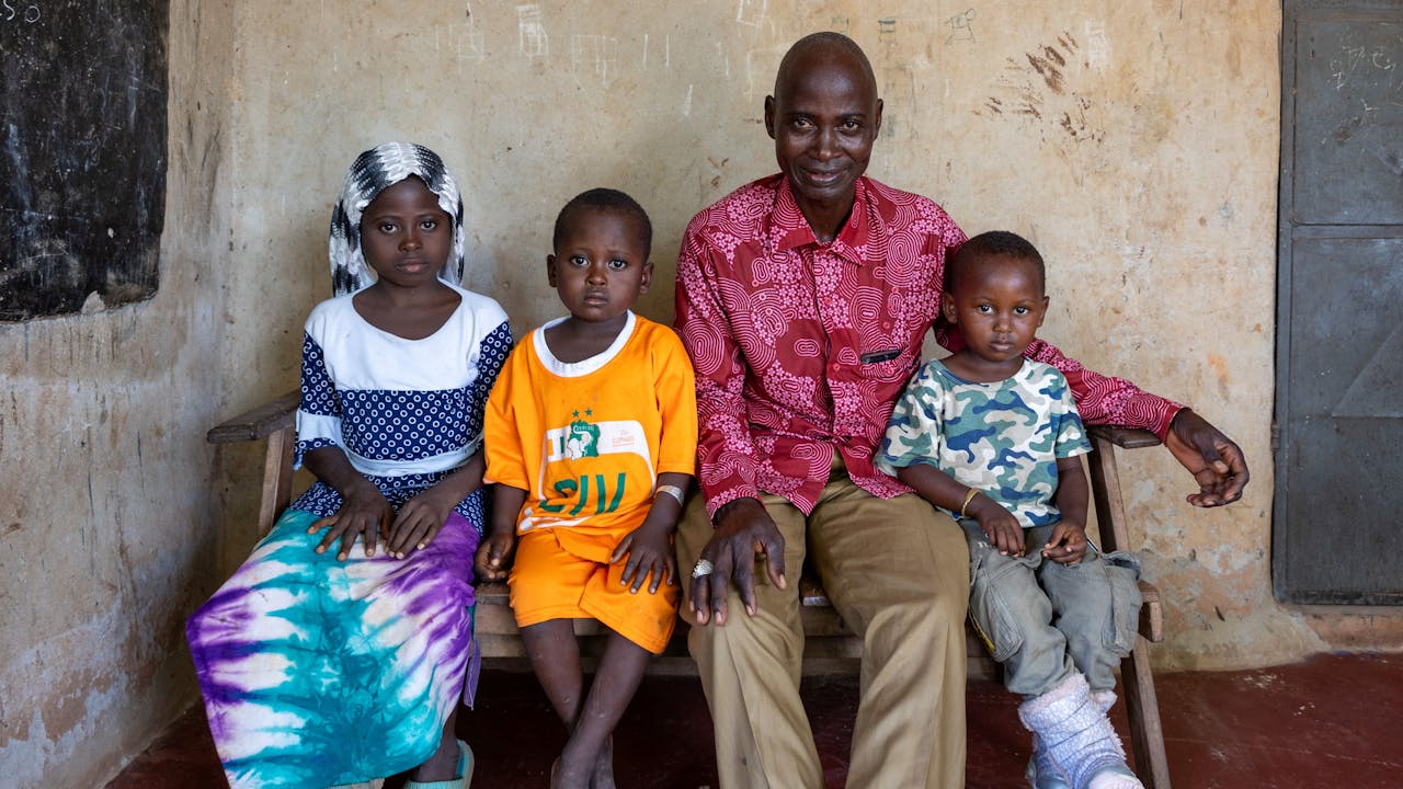 Yabao Oubarou sentado con sus tres hijos pequeños. (2024).