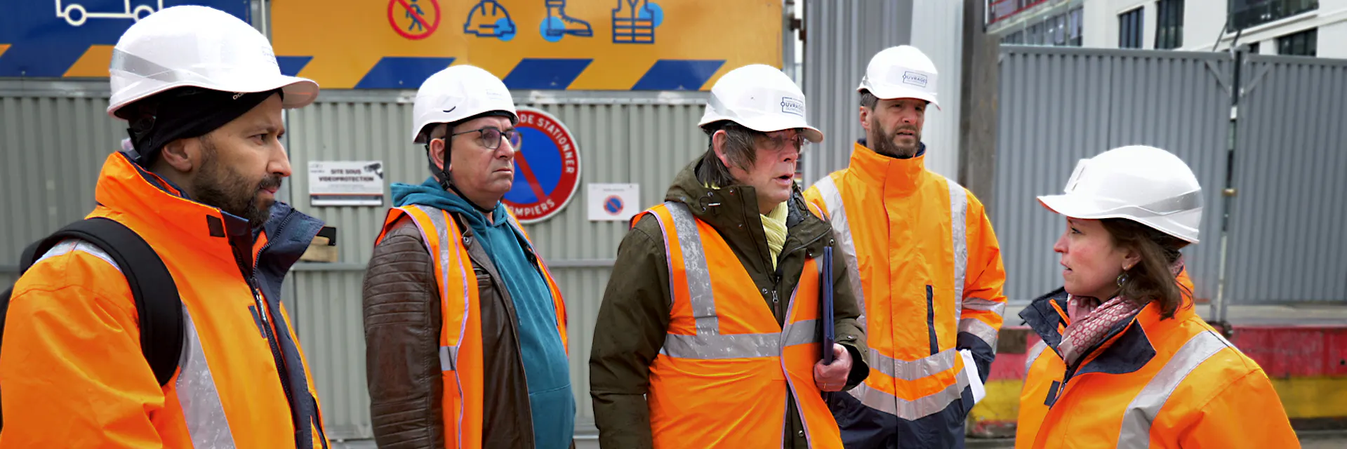 Workers on the construction sites of the Games and representatives of the French trade unions applying the Social Charter on the ground (foremost among them Bernard Thibault, former member of the OIT). On photo they're talking to each other wearing orange vests and white helmets. Oct 2023