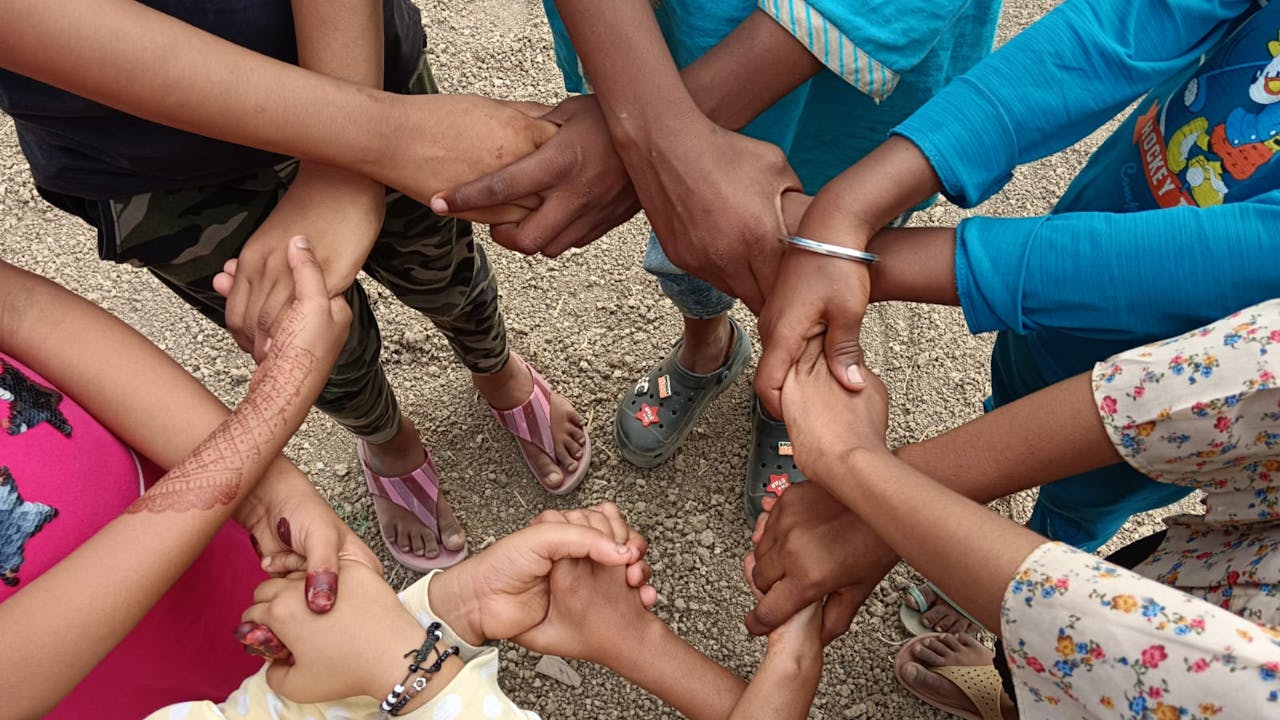 A photo showing seven pairs of young people's hands holding each other, forming a circle. Surat, India. Photo provided by GNSP+. (2024)