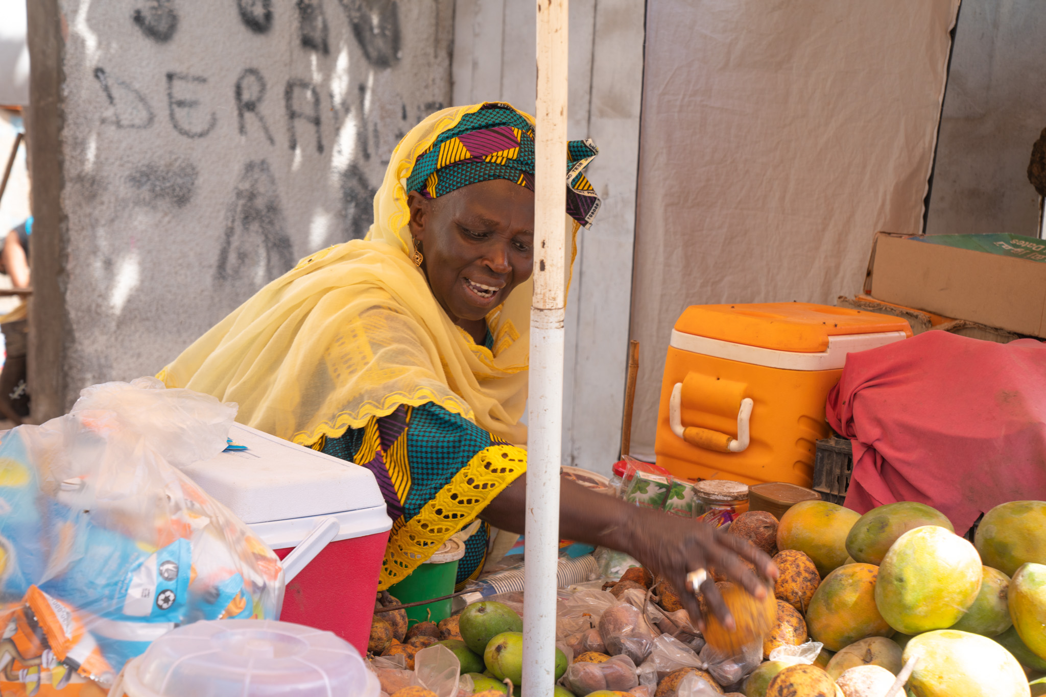 Astou Gningue lays out mangoes on her fruit stall. Pikine, Senegal. (2024)