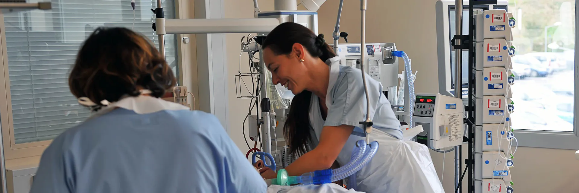 UCI (Unité de soins intensifs). Centre hospitalier de la région d’Annecy (CHRA). Les infirmières s’occupent du patient dans la chambre d’hôpital.