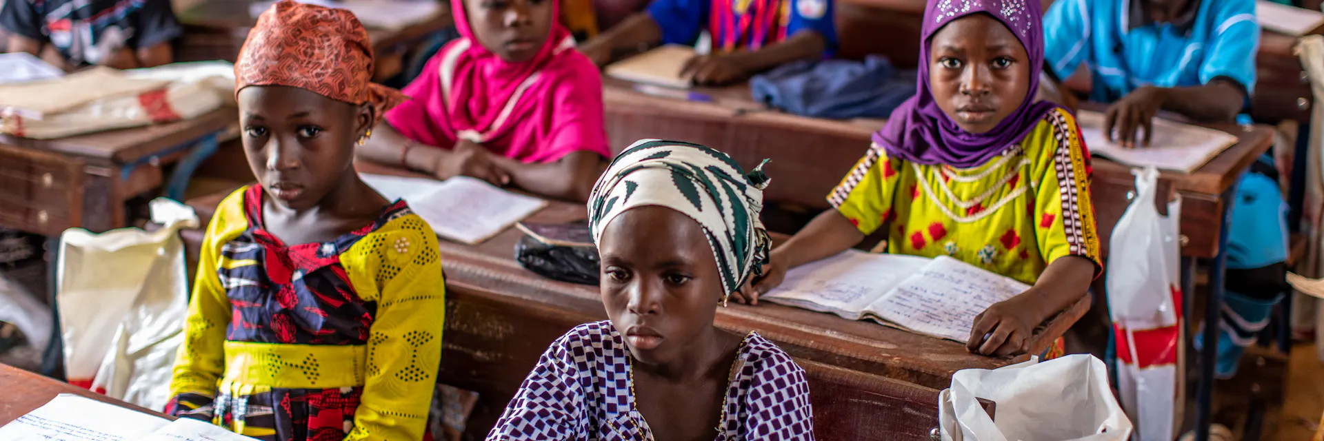 Children sit behind desks in a classroom in Mali.