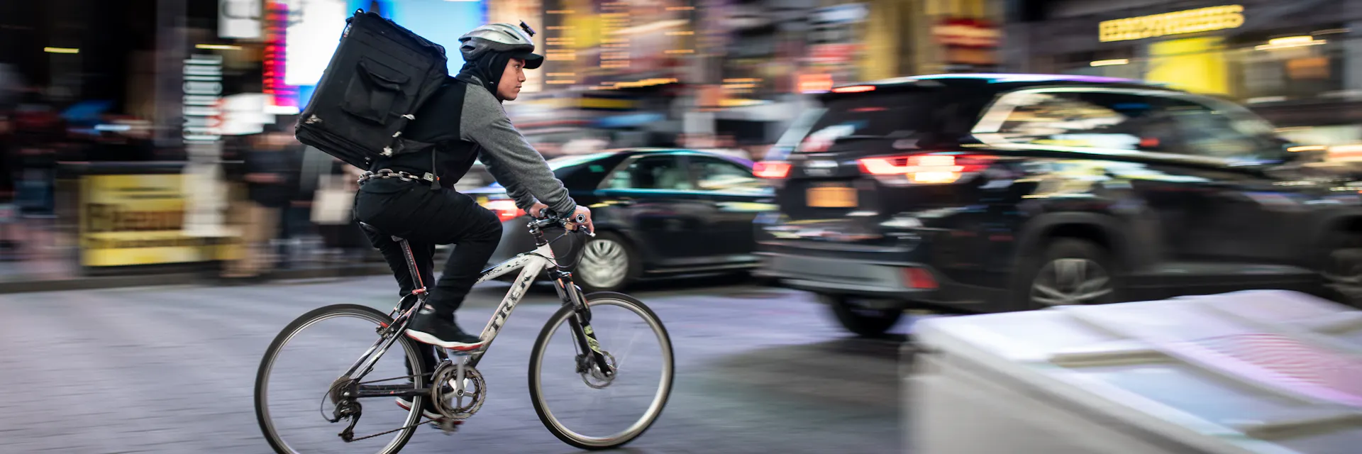 Online delivery worker on a bicycle on a busy road in Hong Kong