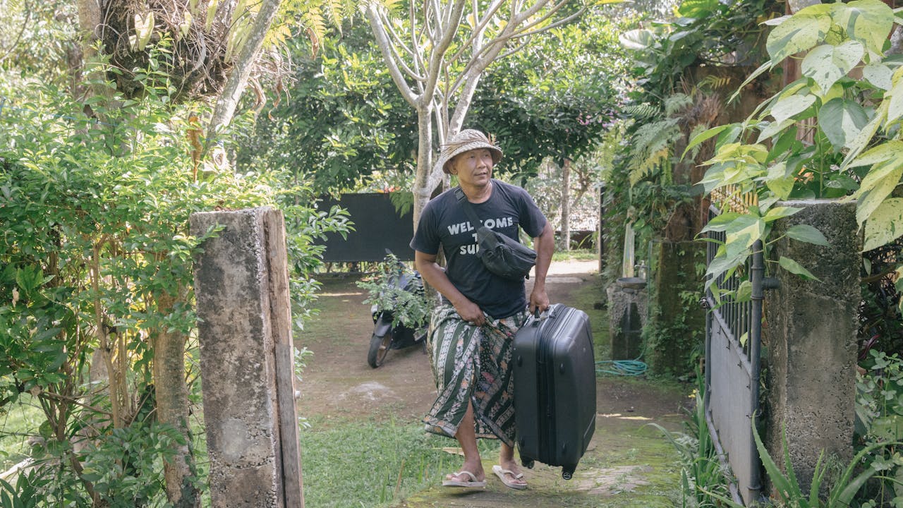 Dekha Dewandana carries a suitcase at the entrance to his homestay.
