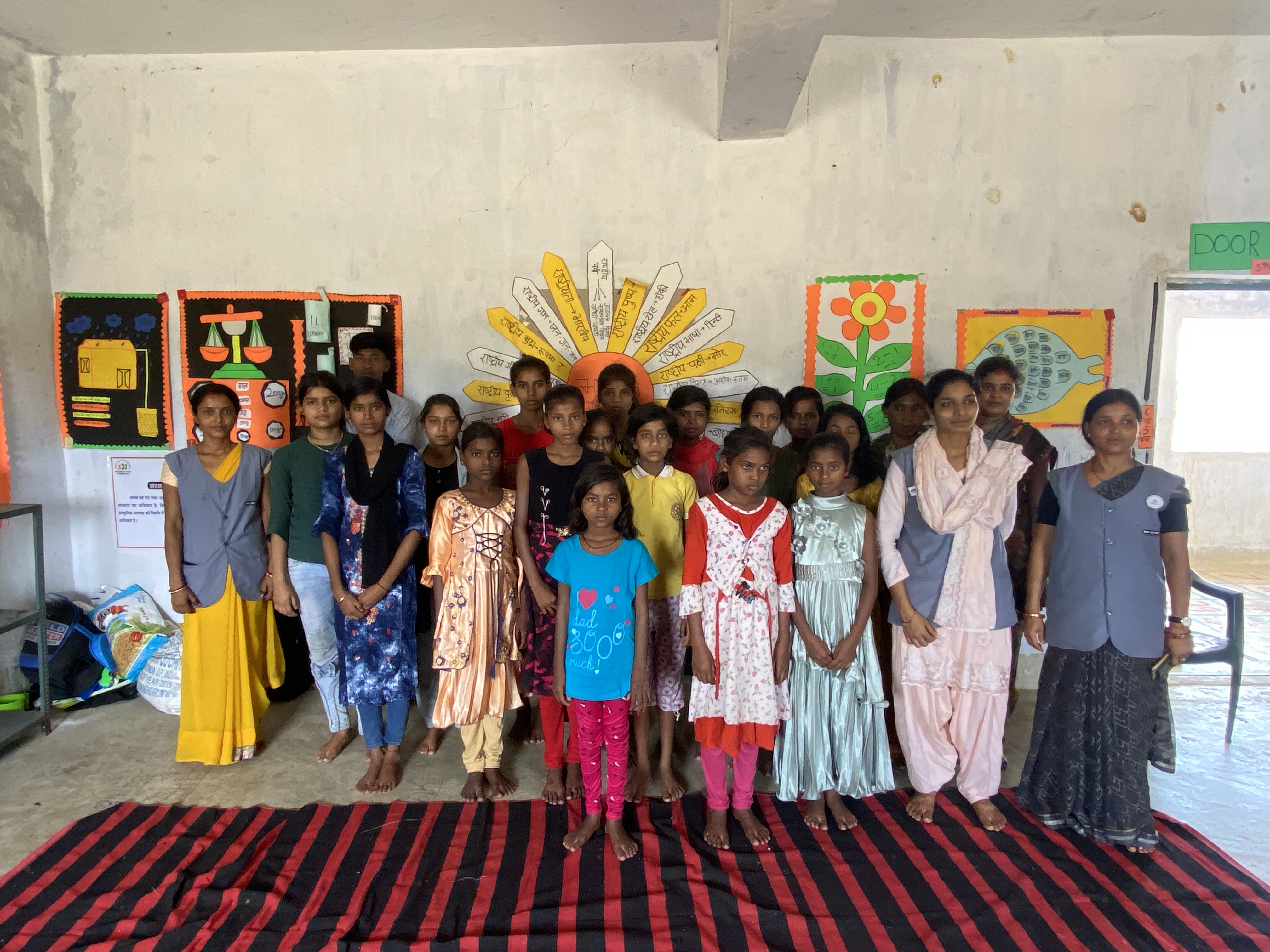 A group of children including Suman Kumari pose for the camera with staff from Balmanch.  