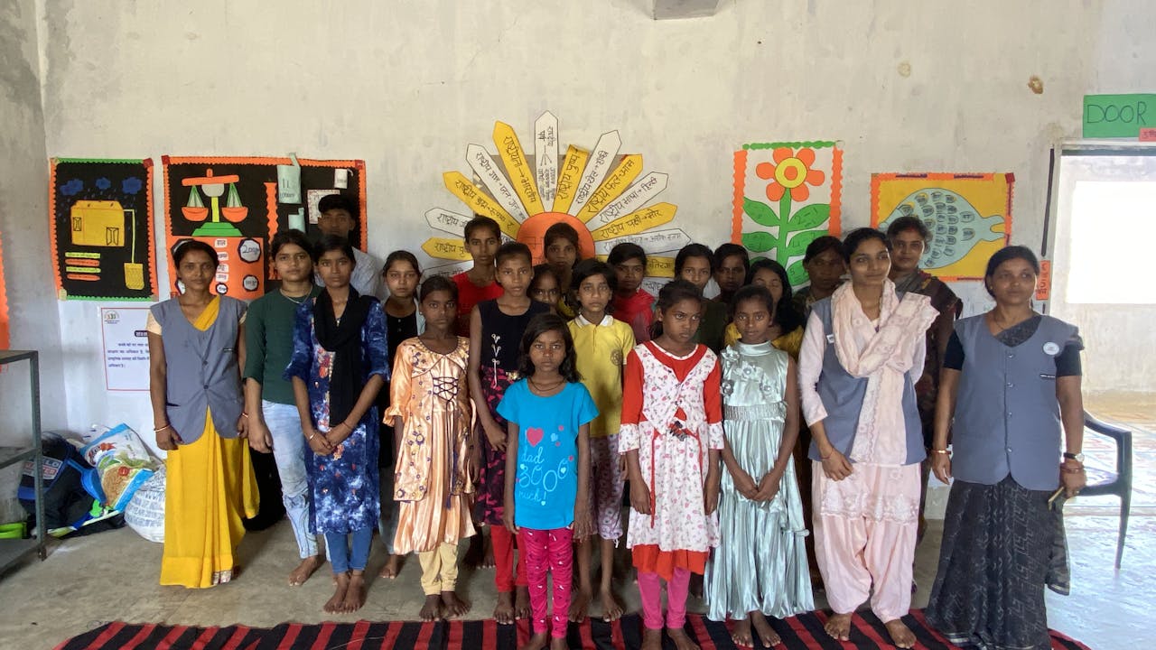 A group of children including Suman Kumari pose for the camera with staff from Balmanch.  