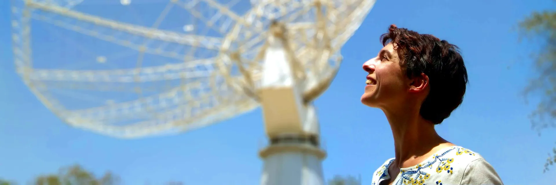 Dr. Natasha Hurley-Walker stands in front of the main dish of the Giant Metrewave Radio Telescope in India.