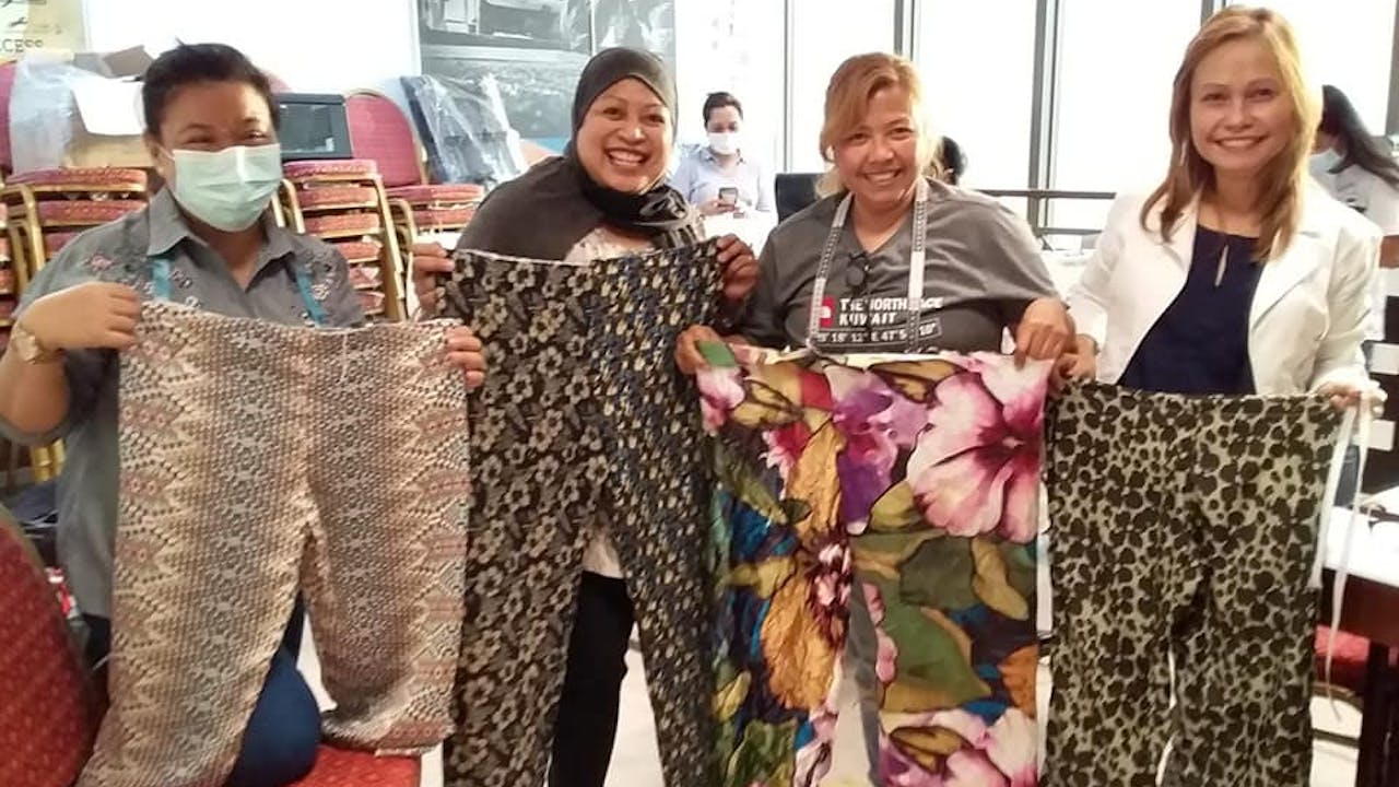 Domestic workers show off the trousers they have made at the sewing livelihood training run by Sandigan. 