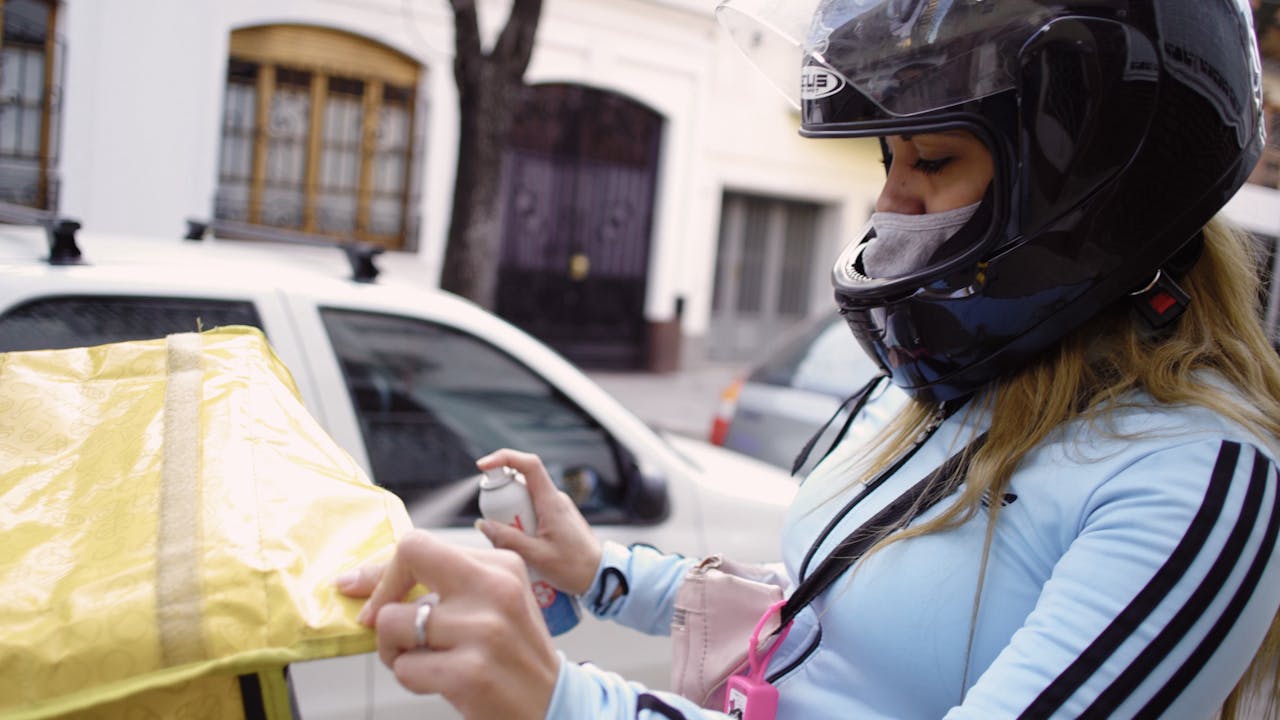 María Belén Fierro disinfects her motorbike after a delivery