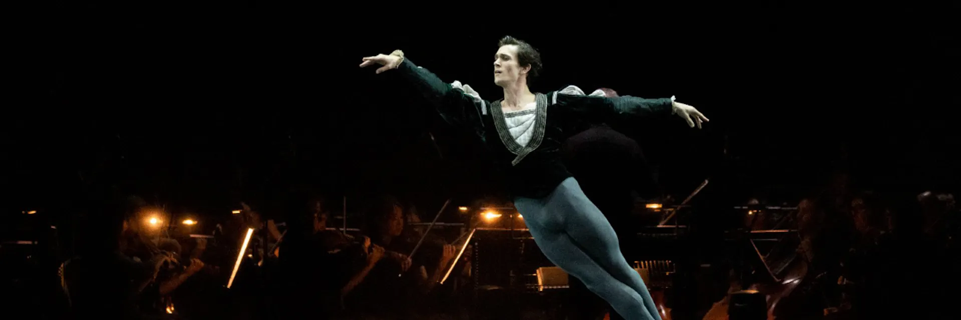 William Bracewell, in costume, jumps across the stage of the Royal Opera House in London while dancing in a ballet performance.