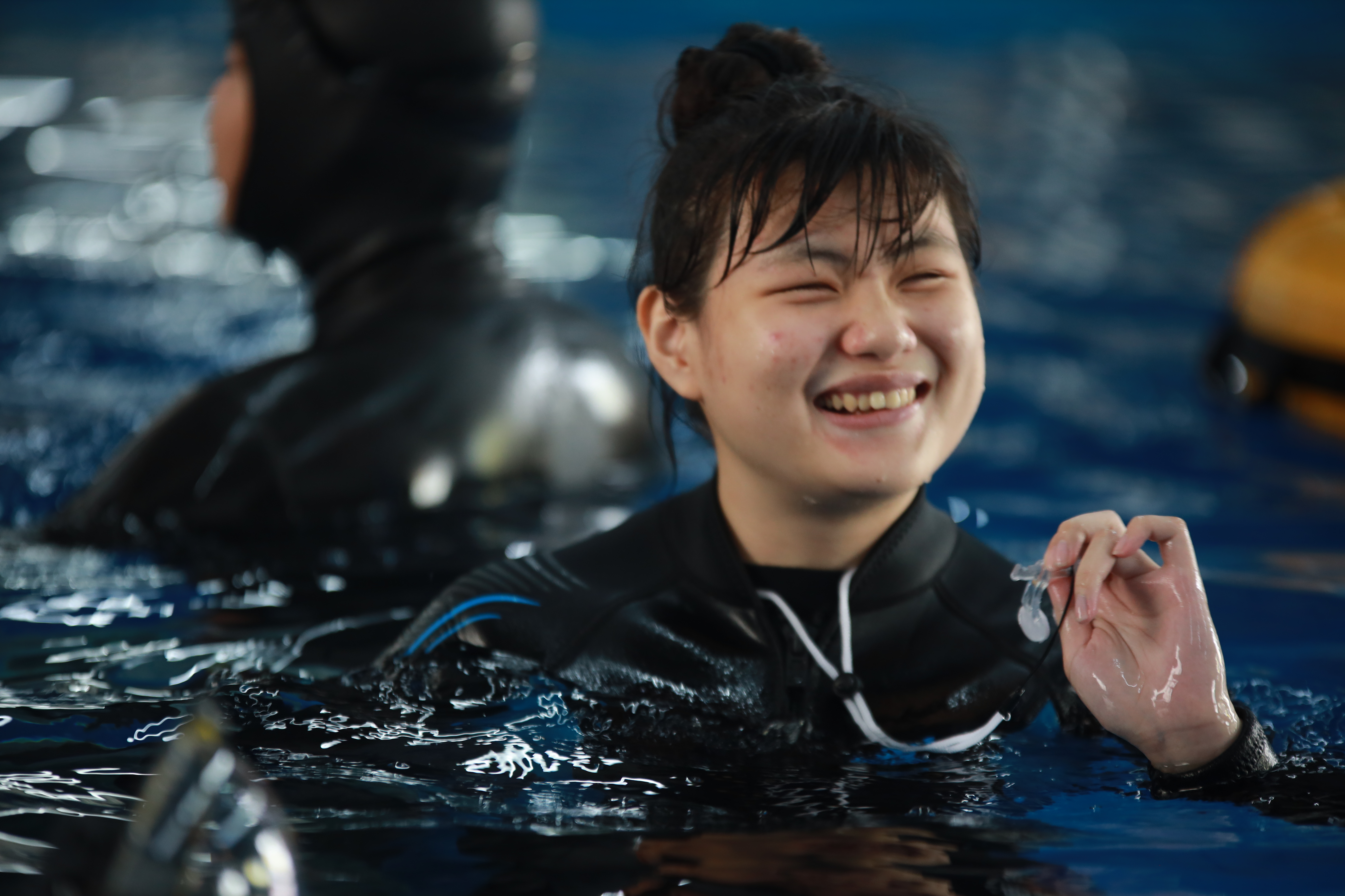 Small Wolf in a swimming pool smiling.