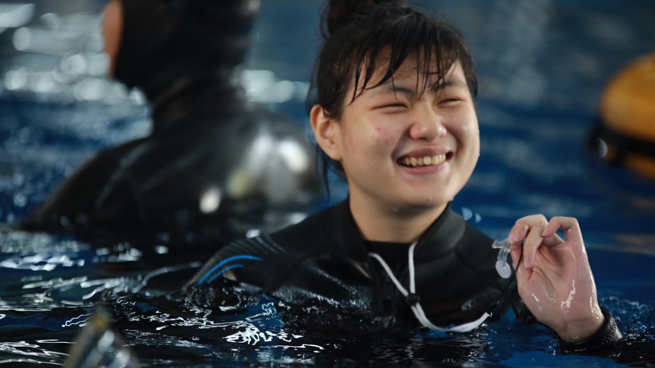 Small Wolf in a swimming pool smiling.