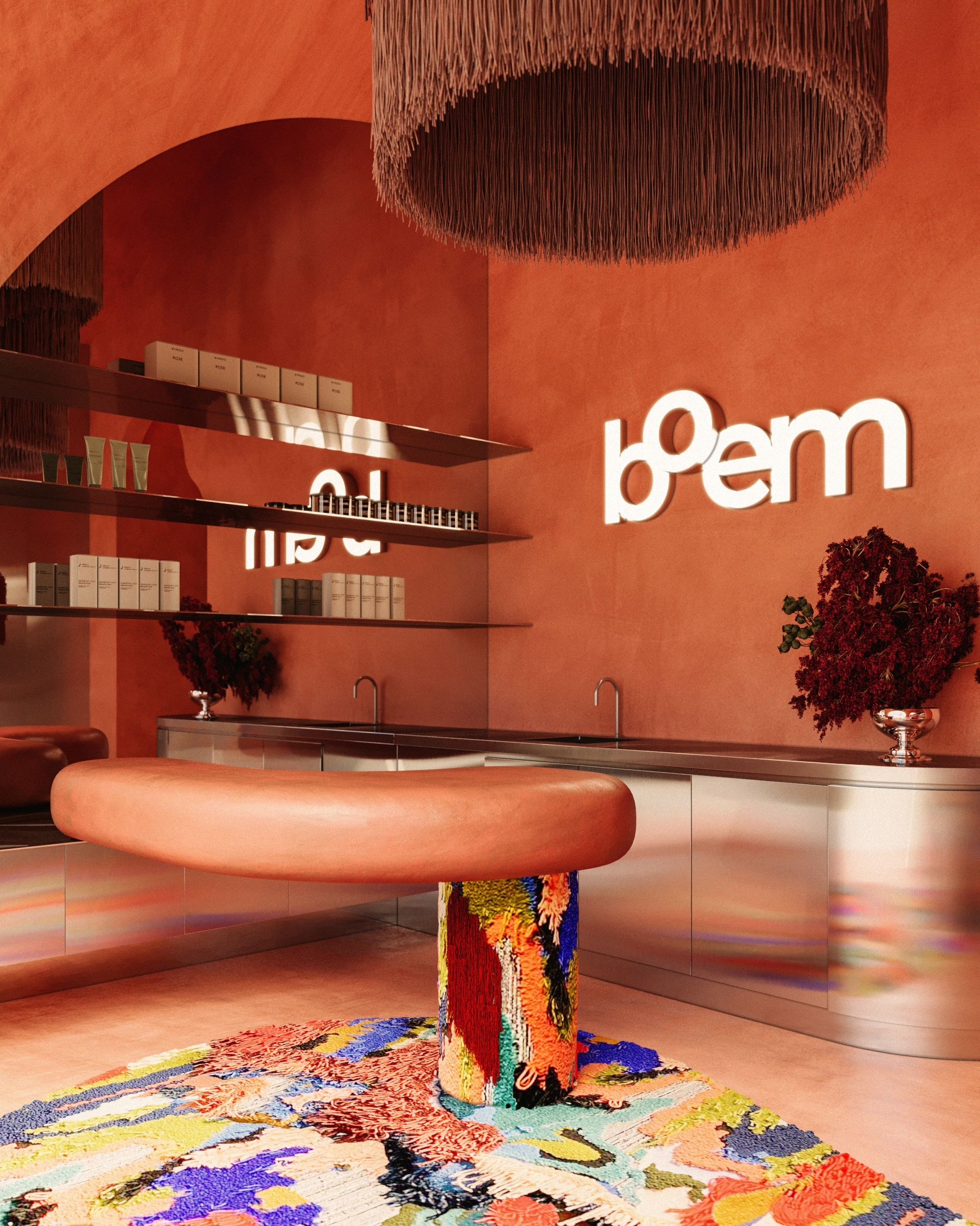 Stylish wellness studio reception interior with coral-toned walls, sculptural desk, colorful artistic rug, and branded Boem signage