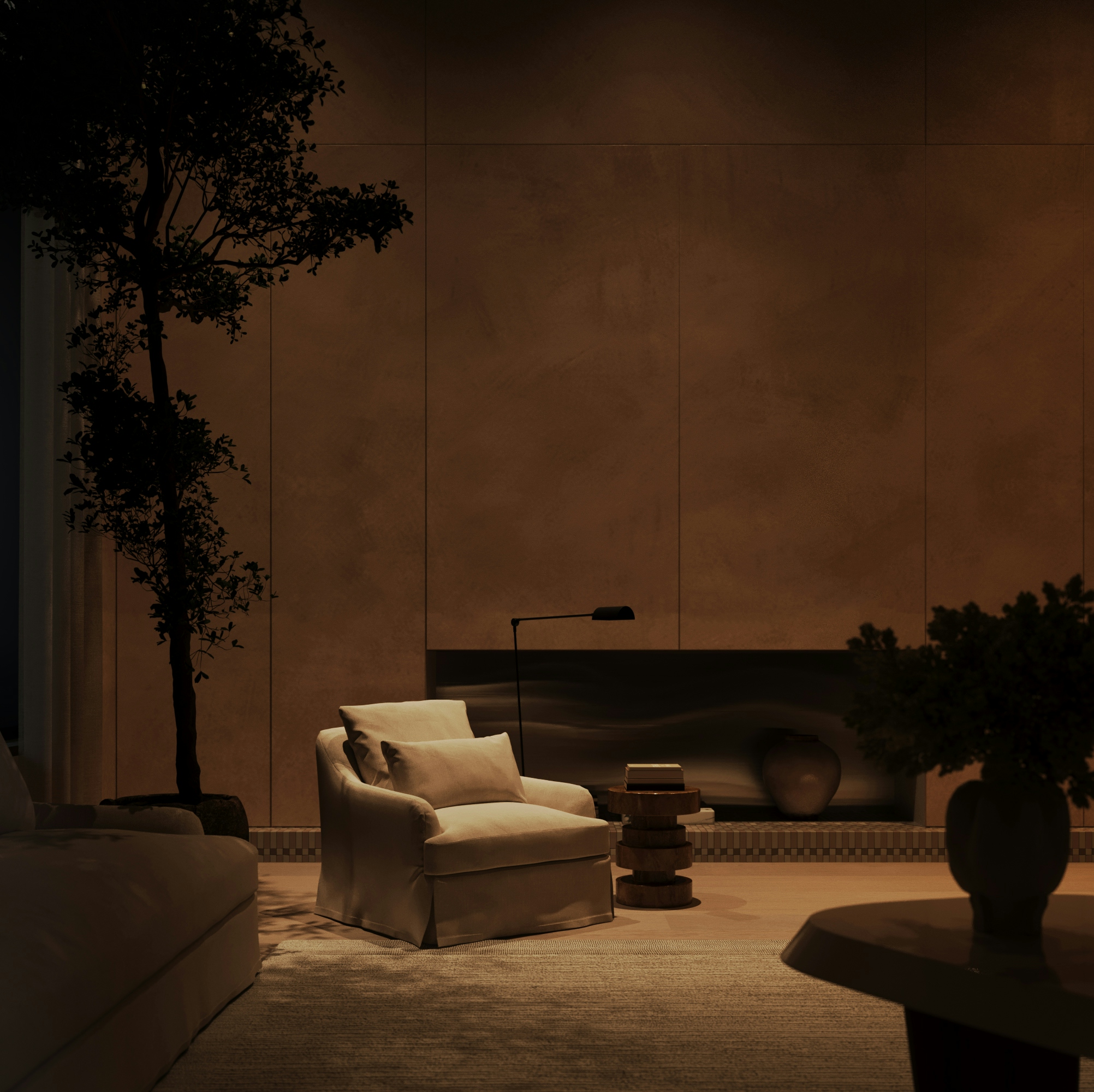 Warmly lit living space at night with armchair, tree, and sculptural wall niche.