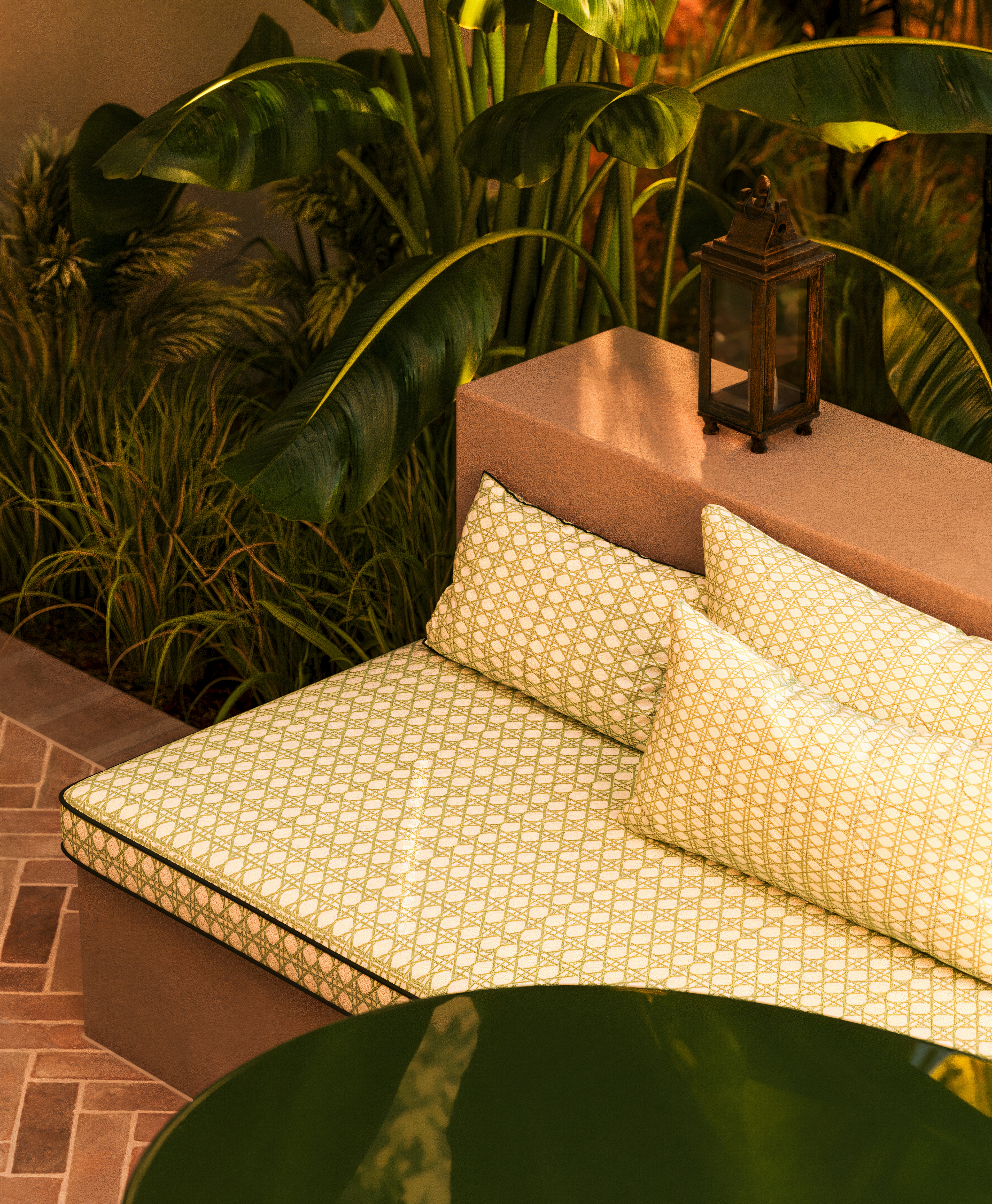 Outdoor built-in daybed with patterned green cushions and lantern surrounded by tropical plants.