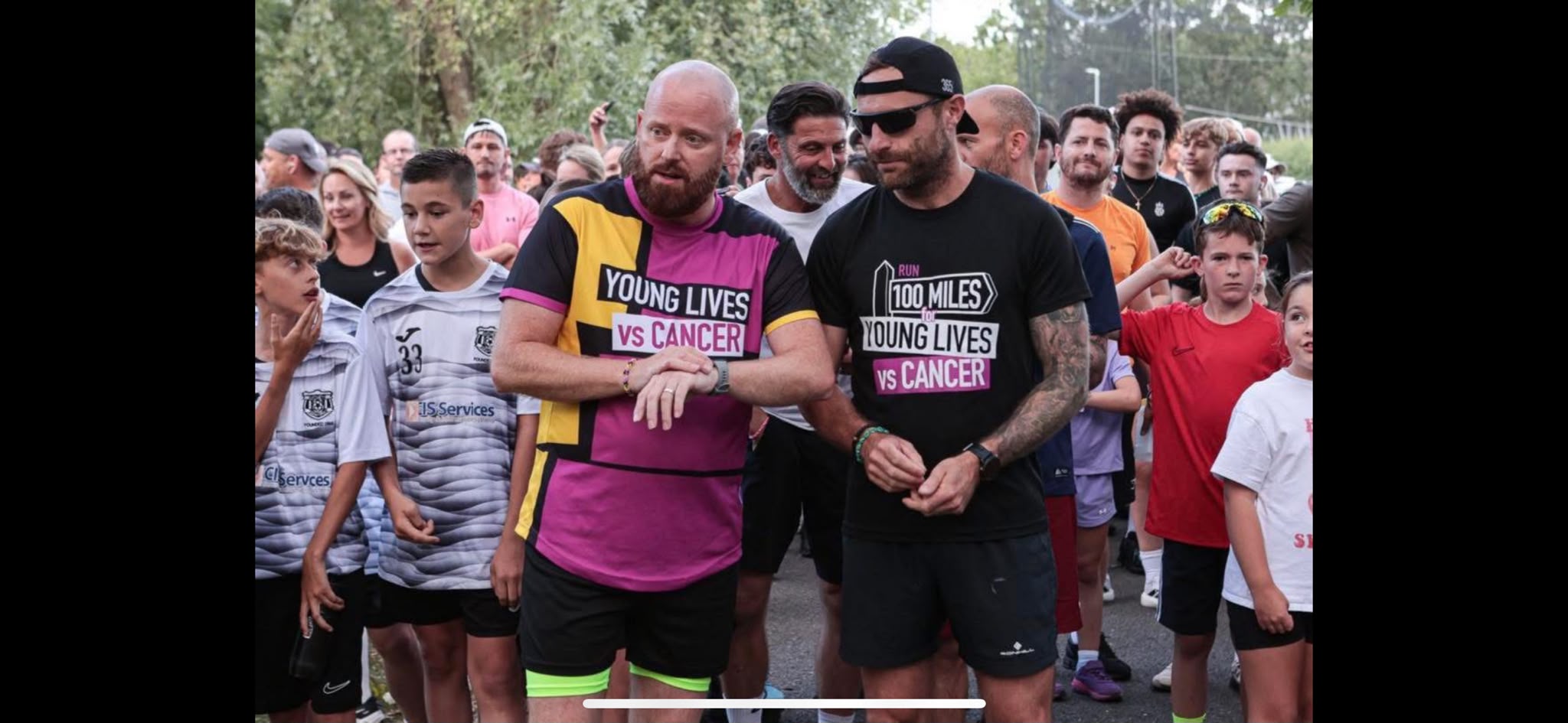 Two fundraisers for Young Lives vs Cancer in a crowd of people, about to start a run.
