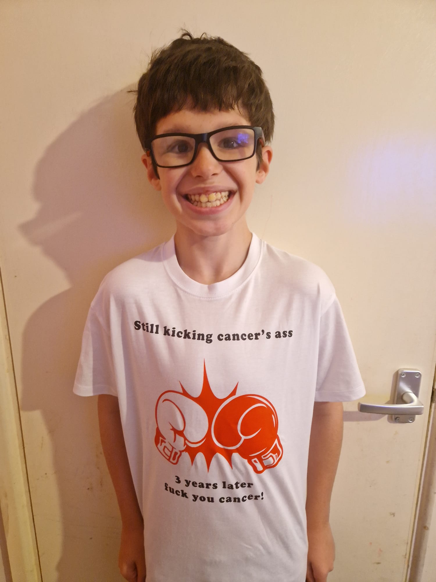 A picture of Dean post treatment wearing a tshirt that says still kicking cancer ass