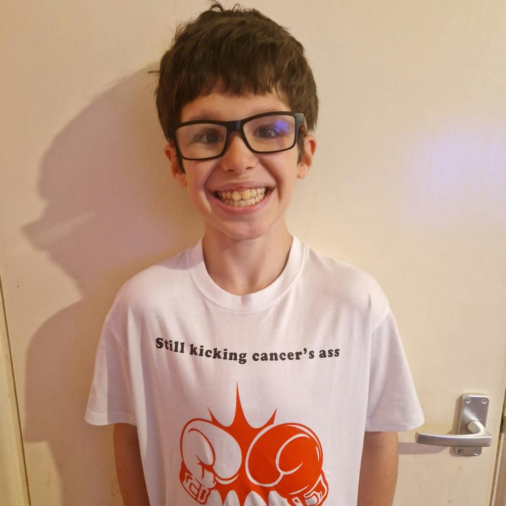 A picture of Dean post treatment wearing a tshirt that says still kicking cancer ass