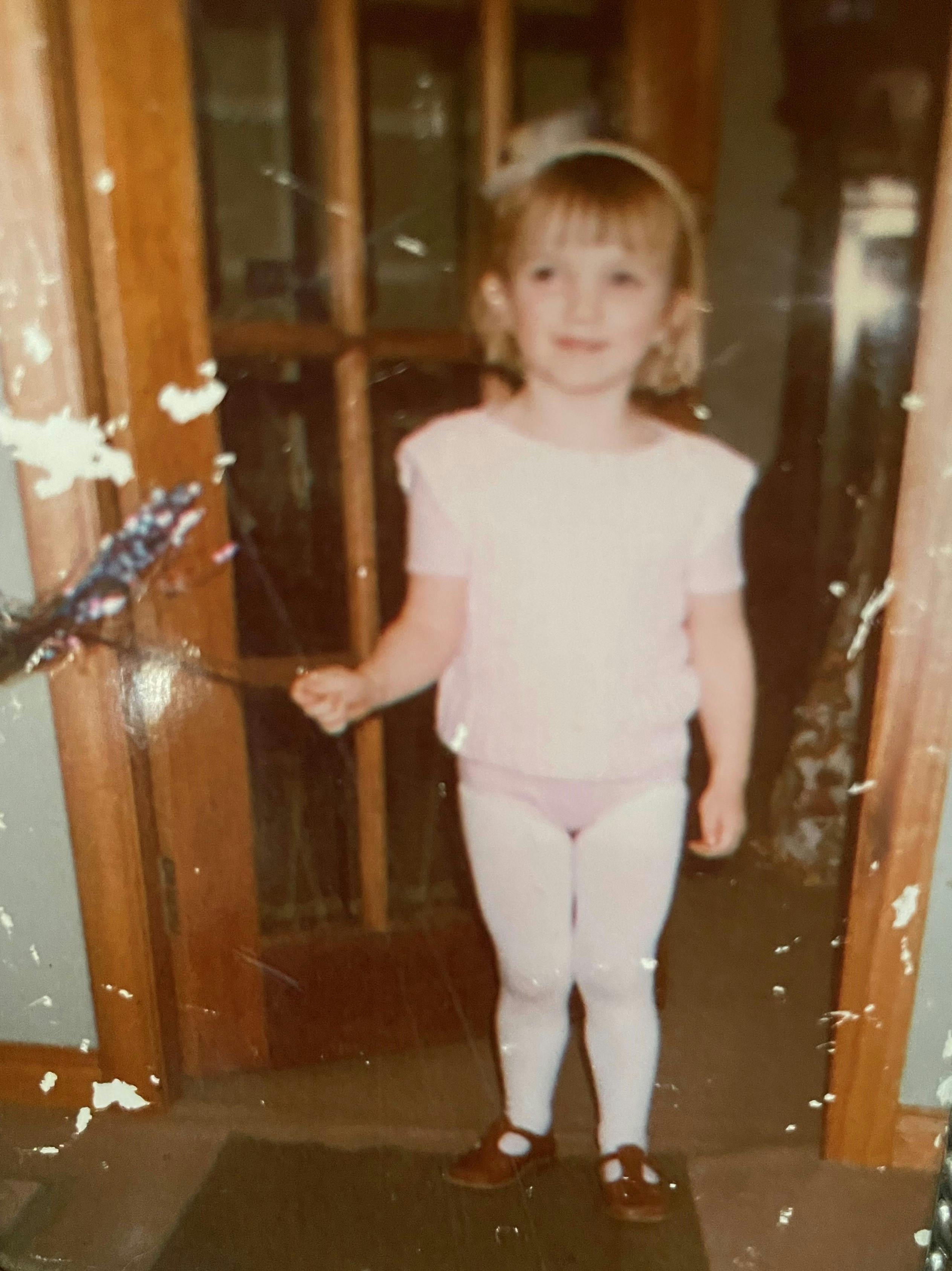 Beth standing in the doorway at home, smiling at the camera