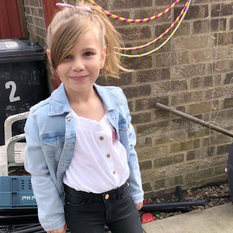 Poppi standing outside in the garden by her skipping hoops