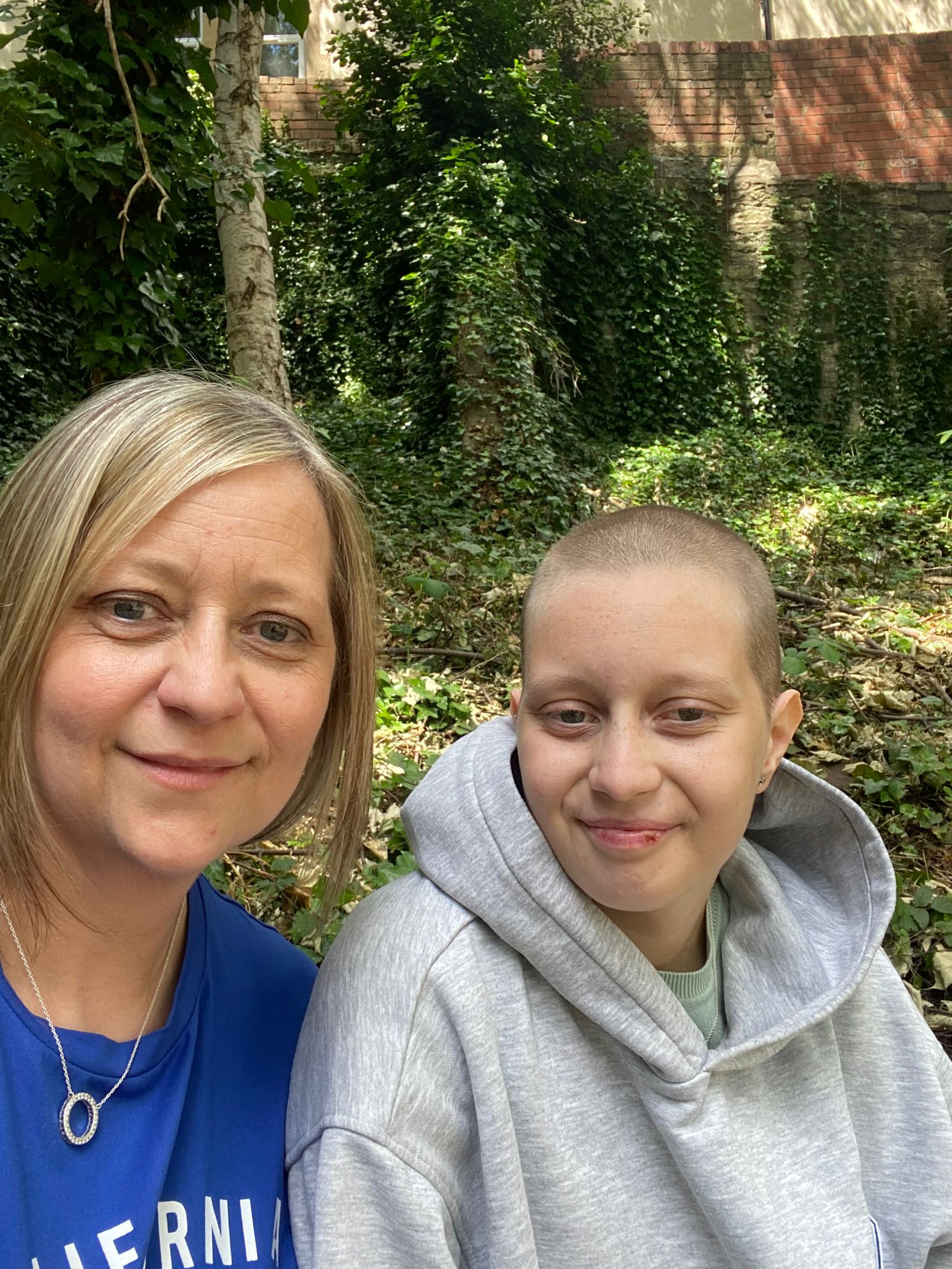 Erin in a grey hoodie, sat next to her mum who is wearing a blue t-shirt