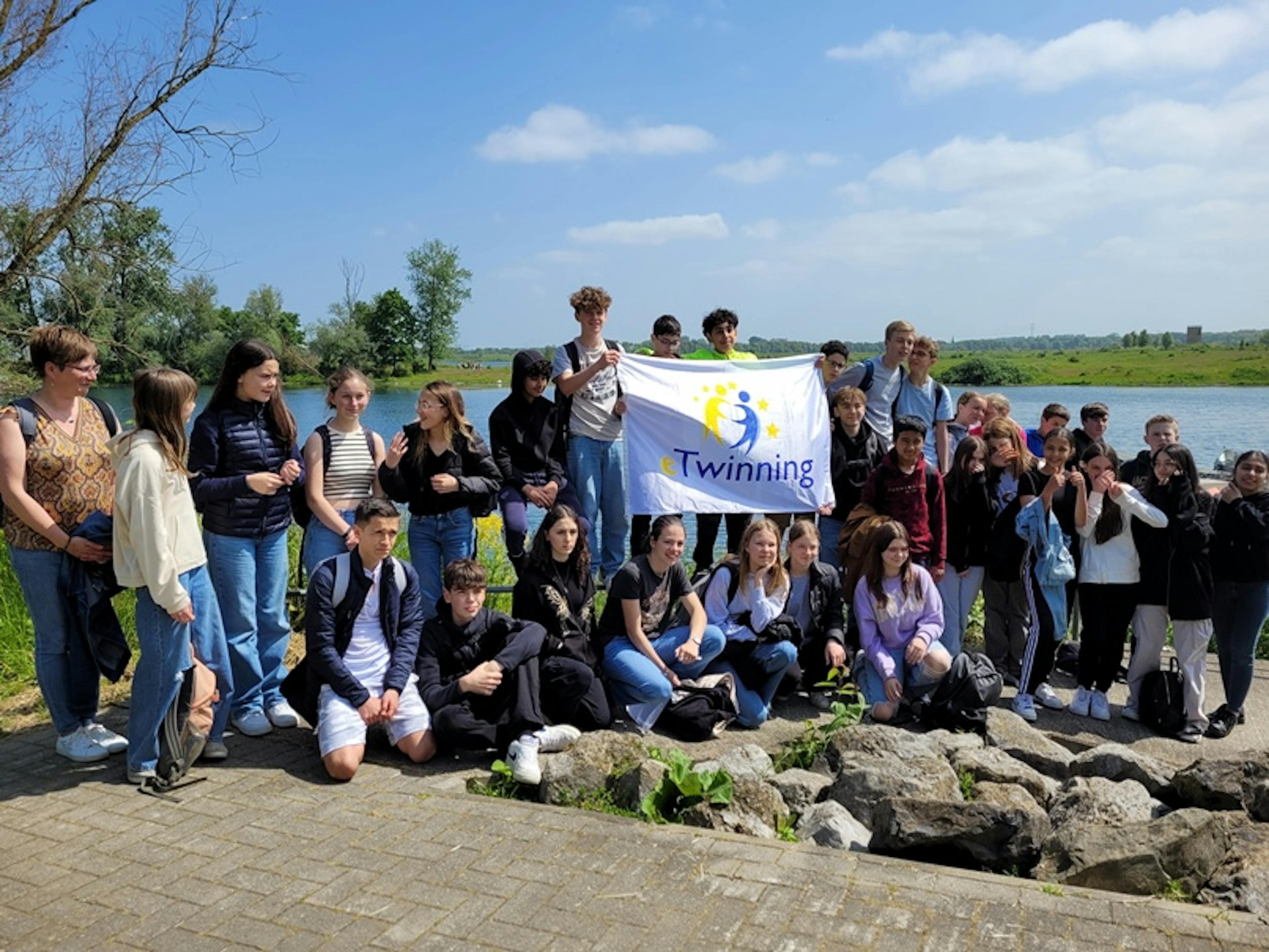 Photo de groupe des élèves portant un drapeau eTwinning lors d'une excursion de l'Inda Arlon.