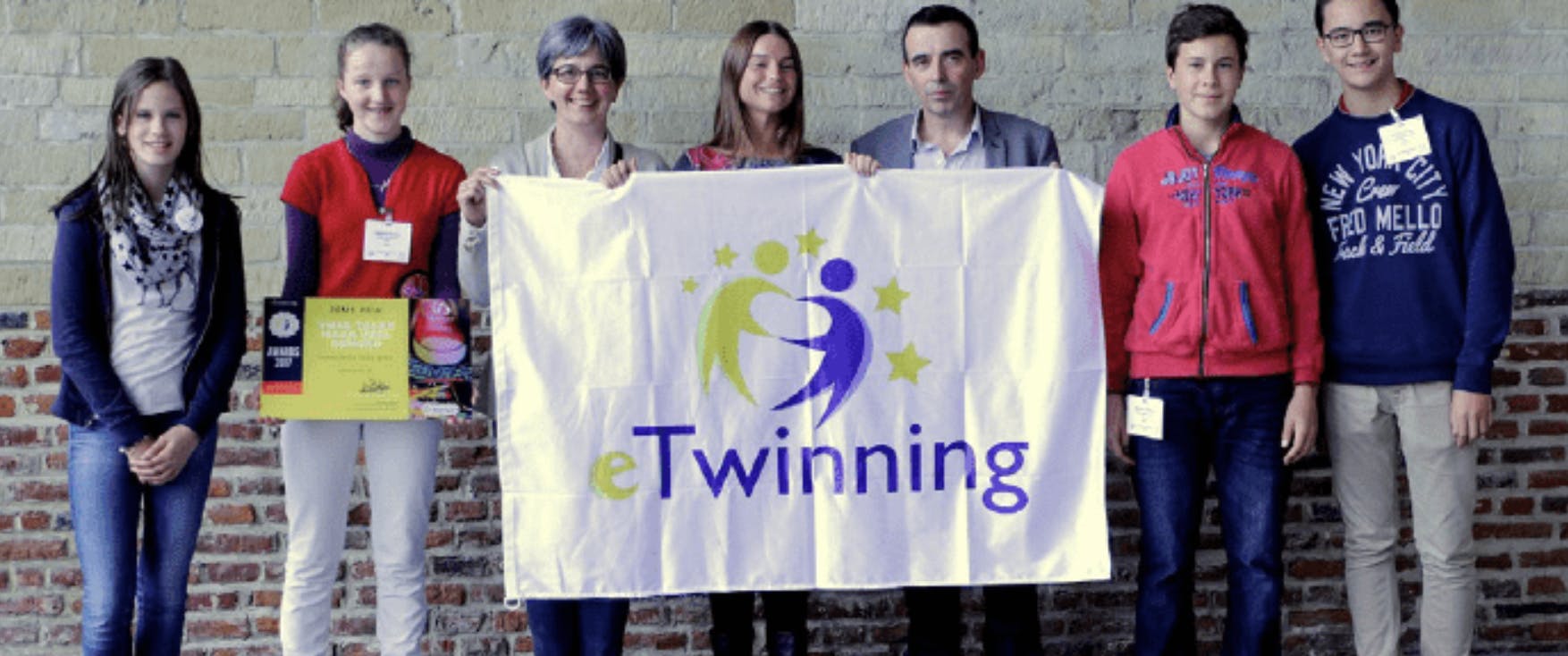 Élèves et enseignants de l'école à pédagogie active d'Arlon portant un drapeau eTwinning.