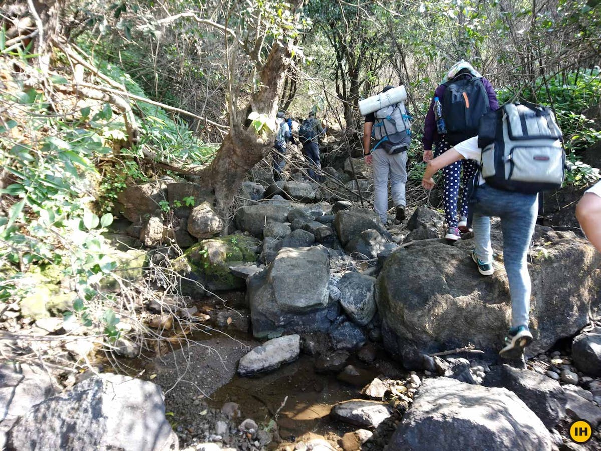 AMK Trek - Trekkers crossing the boulder section inside the forest - Indiahikes - Nitesh Kumar