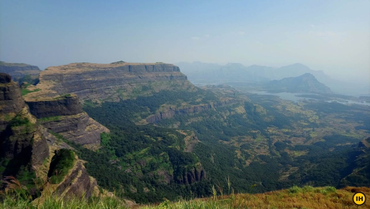 AMK Trek - Stunning view from the top of Kulang fort — Madan and Alang forts on the left, Ghatghar reservoir on the right and Bhandardara reservoir behind Alang fort far center - Indiahikes - Nitesh Kumar