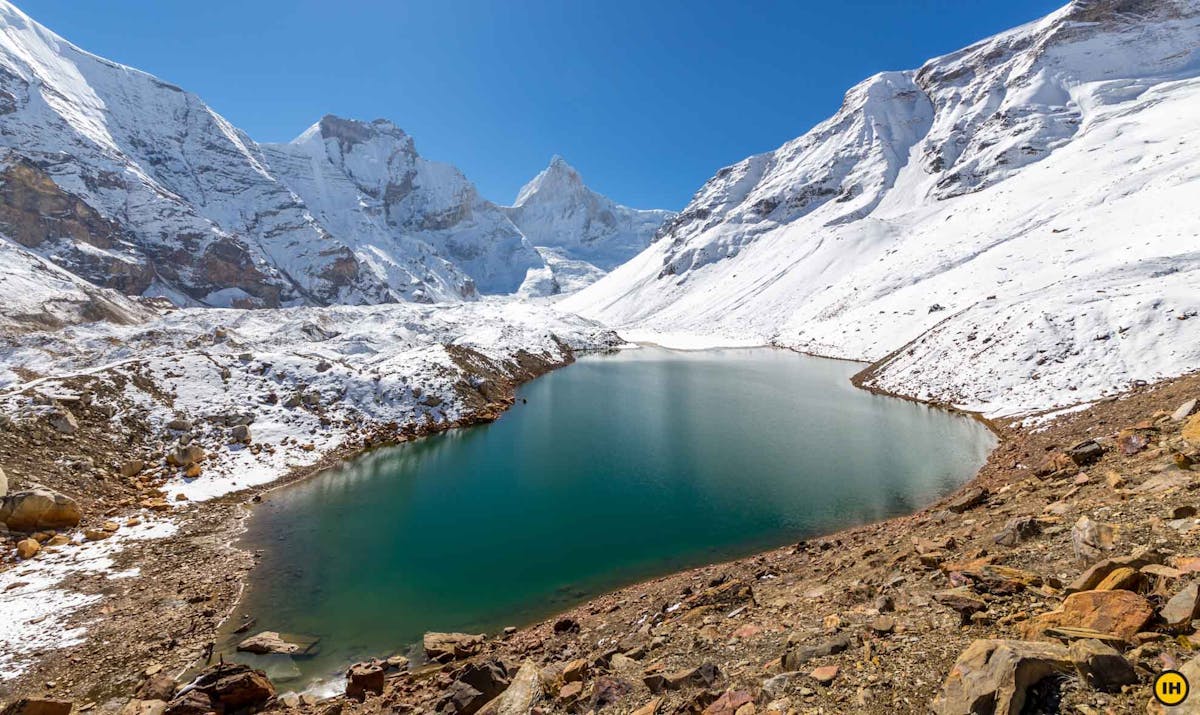 A view of Kedartal lake surrounded by mountains covered in snow