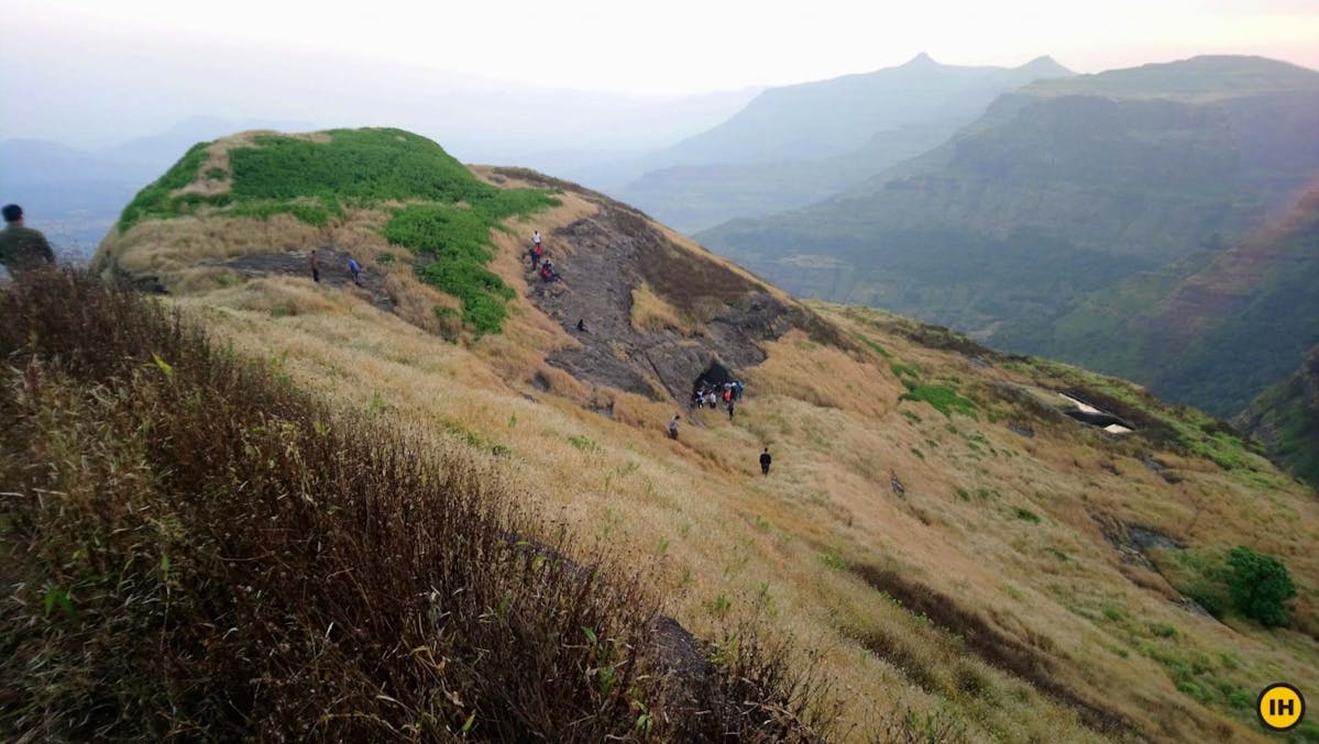 AMK Trek - From the Madangad summit, you see the water cisterns on the right, cave in the center, and the highest point on the left - Indiahikes - Nitesh Kumar