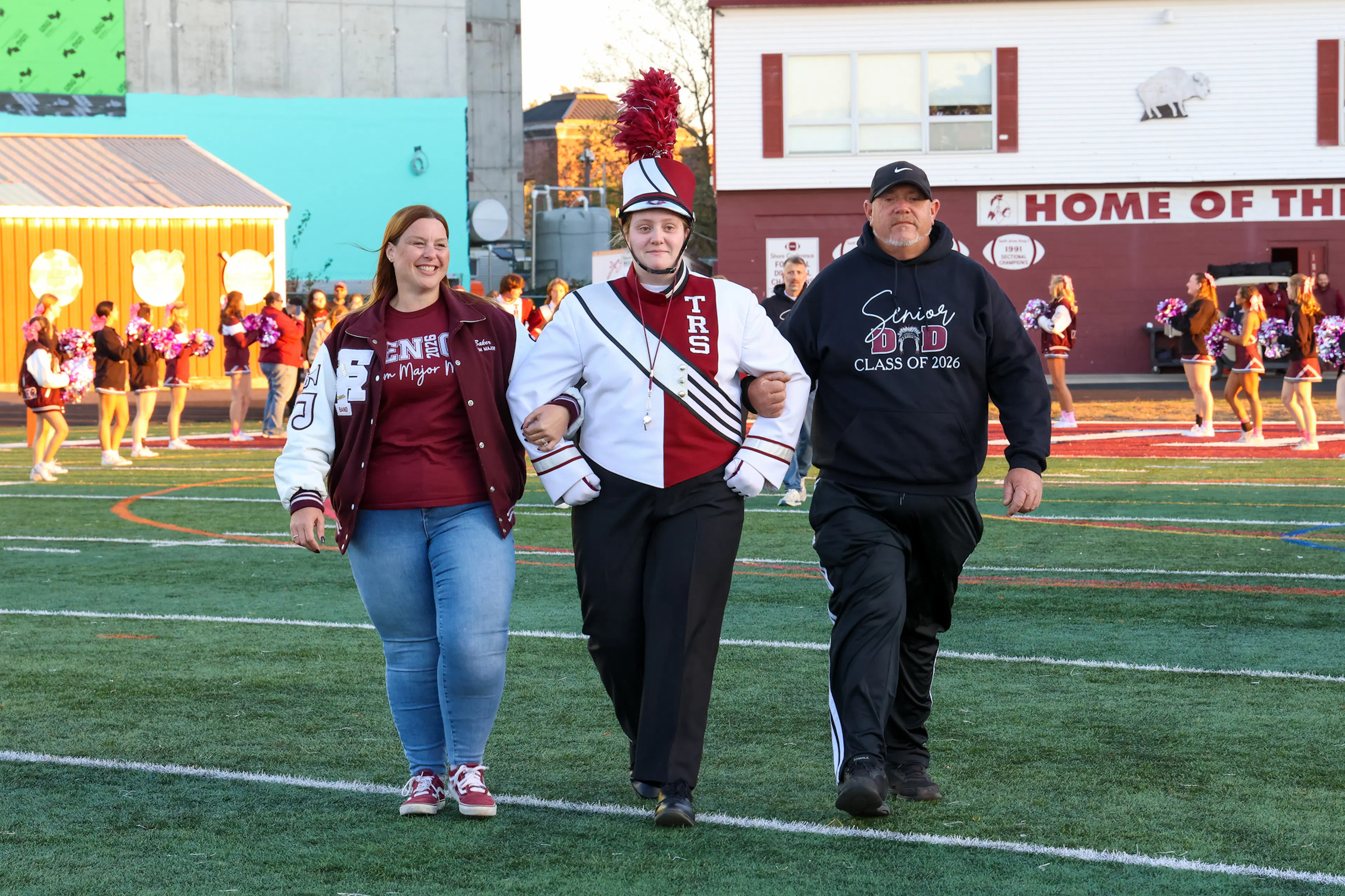 Drum Major and parents walking on football field
