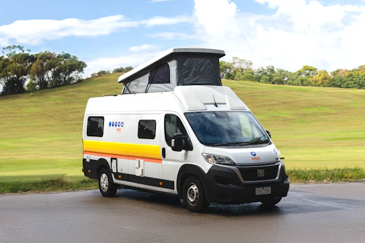 White campervan with pop-up roof parked.