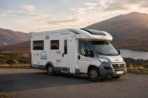 Front and side view of a large camper van with a high roof, no roof tent visible.