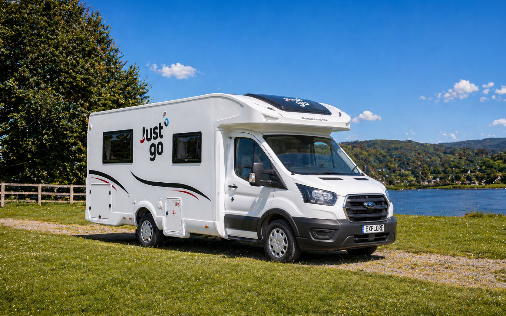 Front-side view of a large white camper van with over-cab section, no roof tent visible.