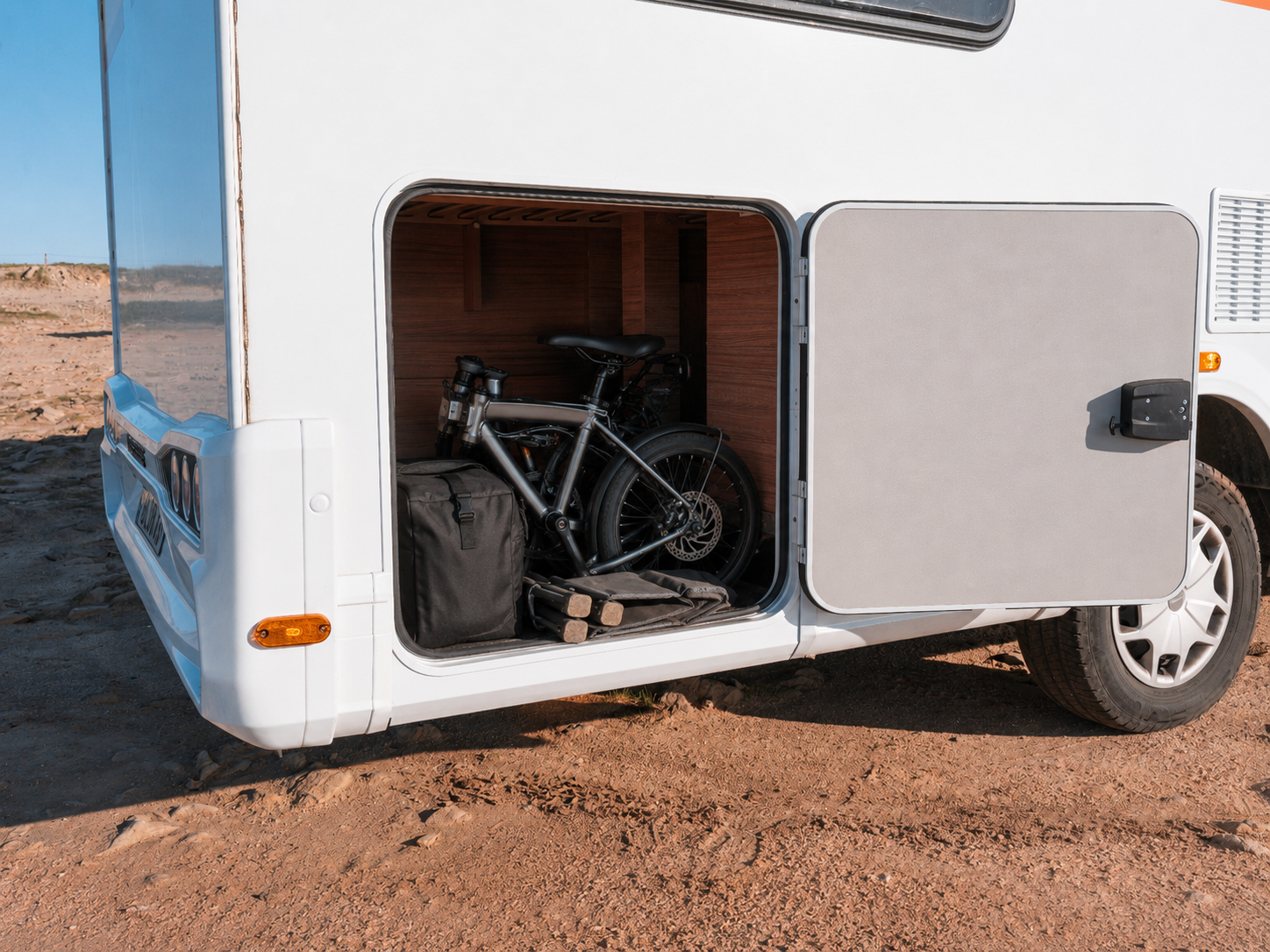 Side view of van rear storage compartment with bicycle, bags, and equipment inside.