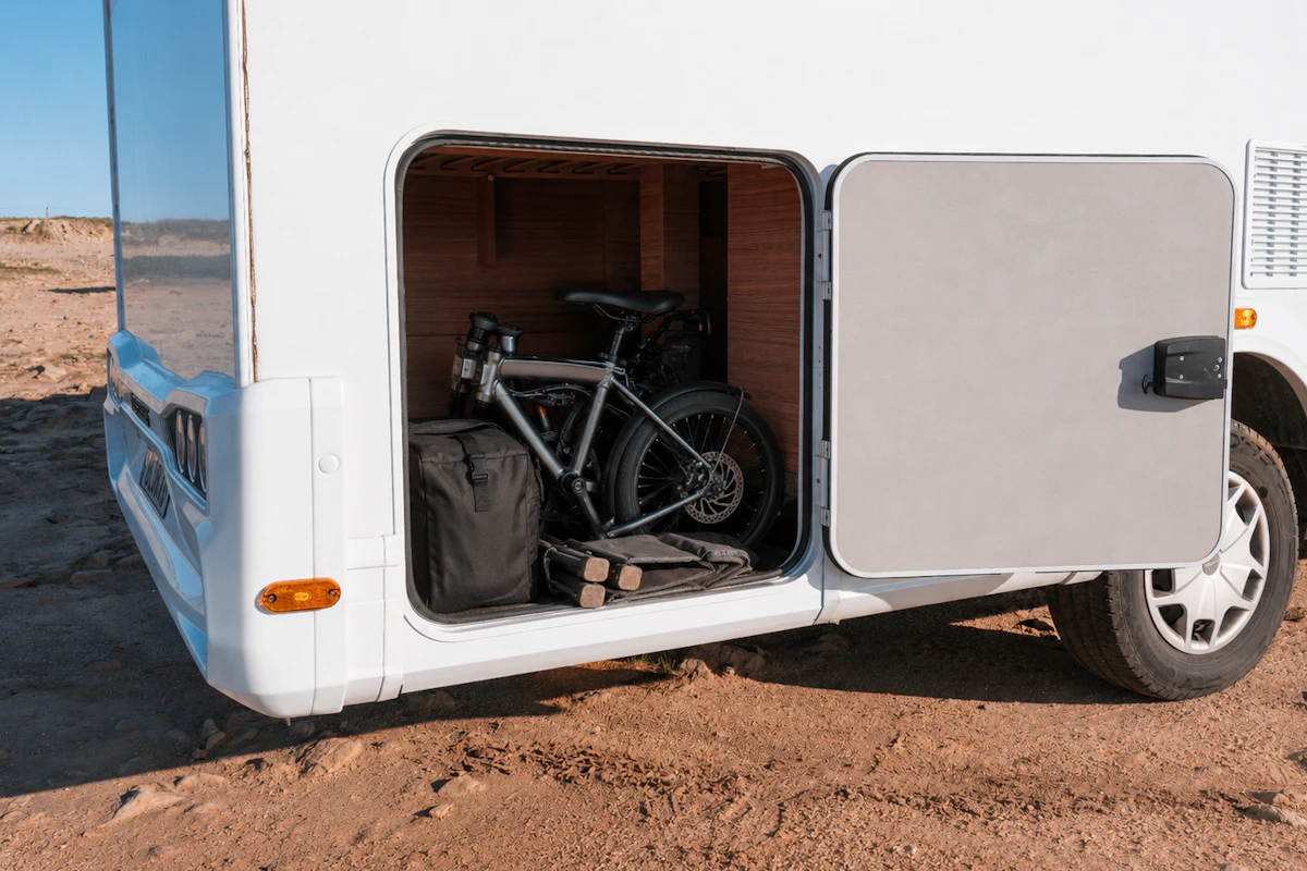 Side view of van rear storage compartment with bicycle, bags, and equipment inside.