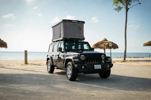 Front view of mid-size black van with roof tent.