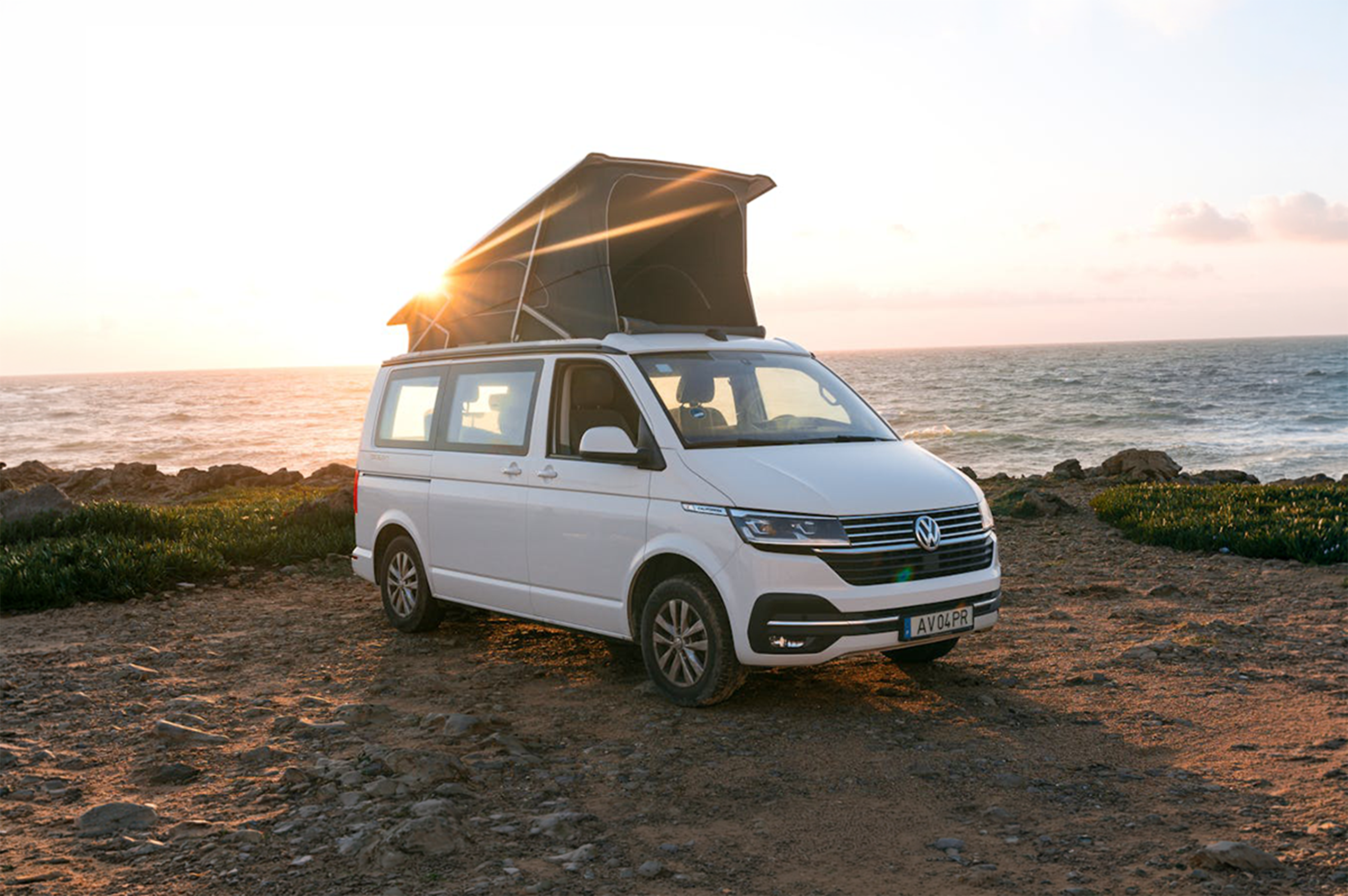 Front side view of medium camper van with roof tent extended.