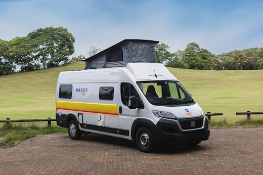 Medium campervan side view with extended roof tent visible.